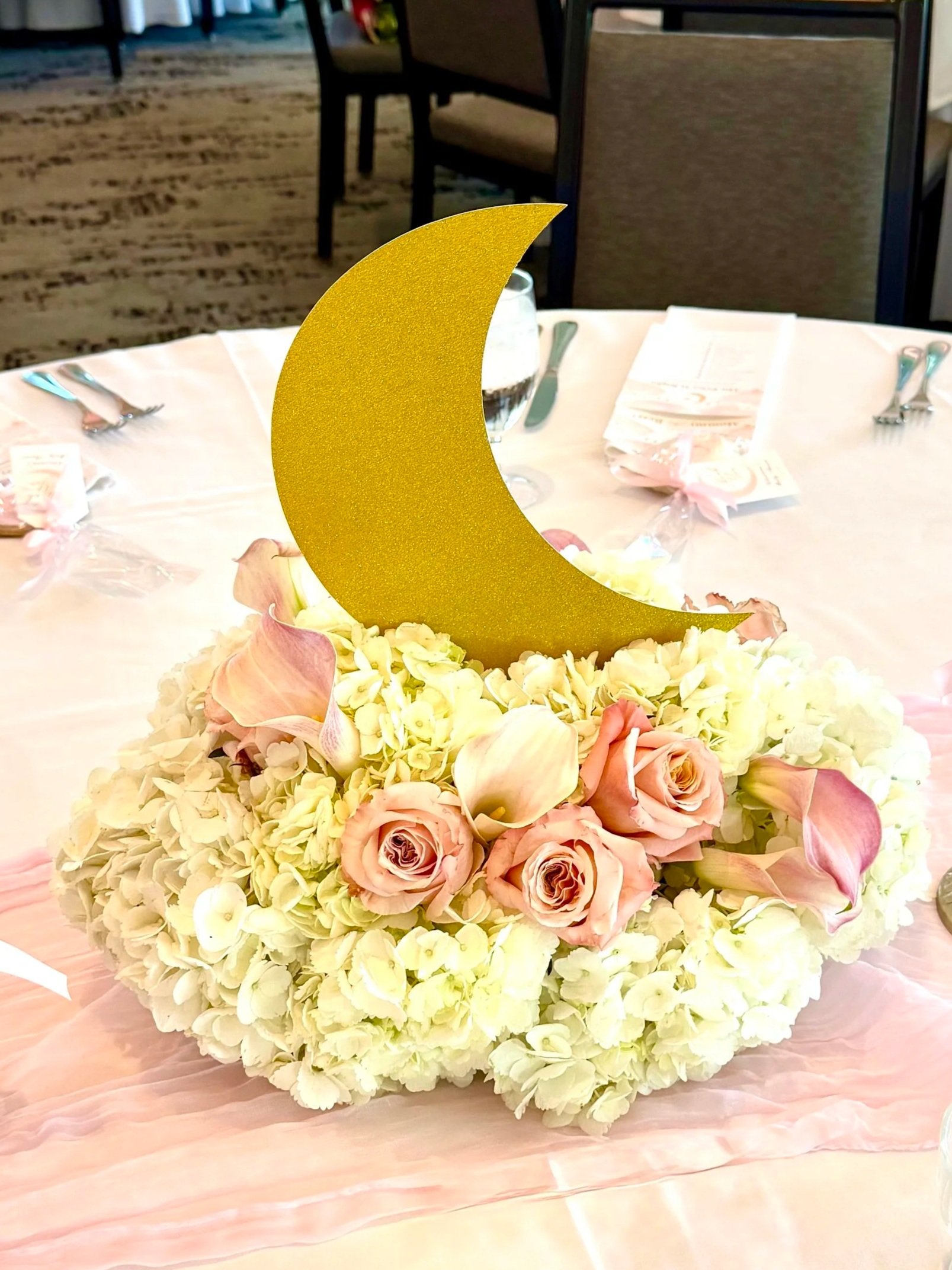 Over the Moon Baby Shower centerpiece with white hydrangeas, pink roses and pink lillies that resemble a cloud
