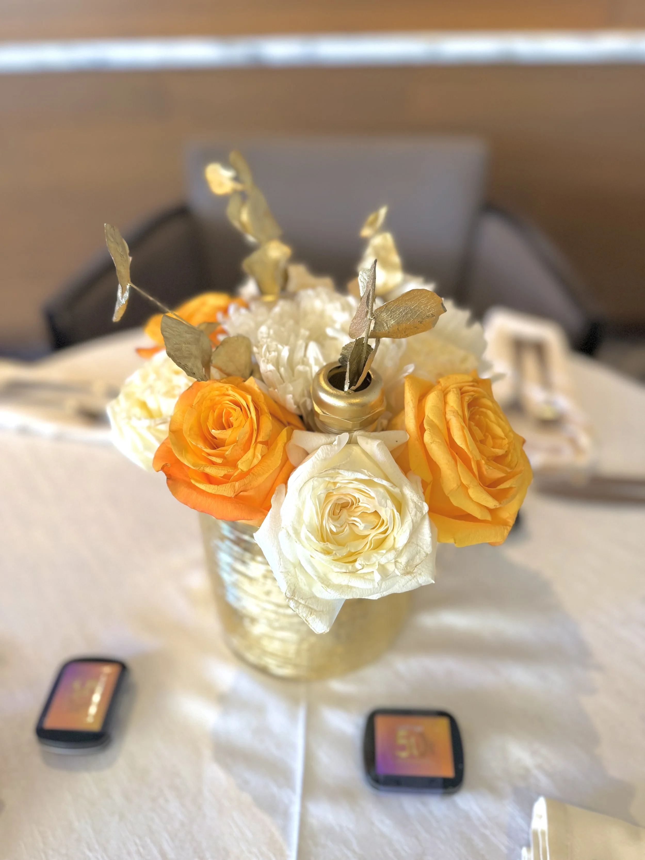 Flower centerpiece for a corporate event that features hardware accents and brand colors in NJ