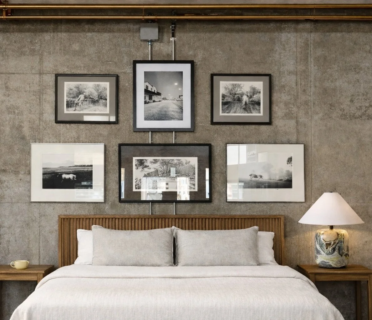 The gallery wall in this Denver Highlands loft showcases cherished photography. The exposed pipes provide unexpected visual interest to the grouping.