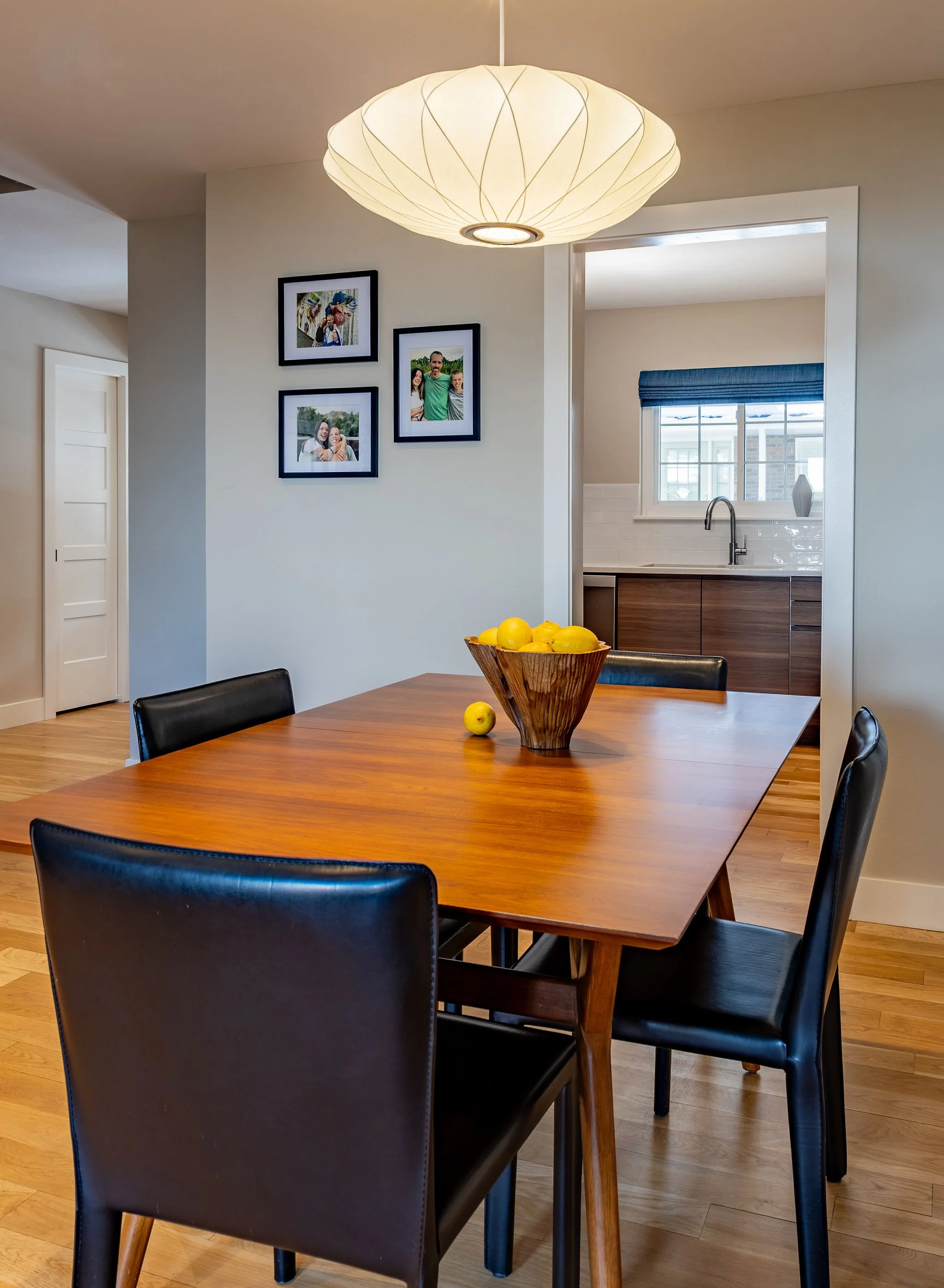 The homeowner favors a clean MCM design style captured by this Herman Miller bubble light, Room & Board chairs and West Elm table.