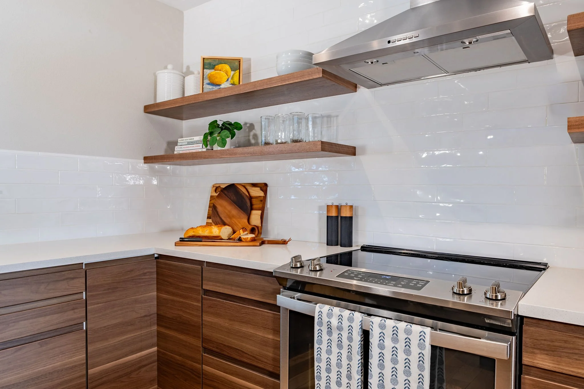 Modern floating shelves provide much-needed storage in this small Littleton townhome kitchen.