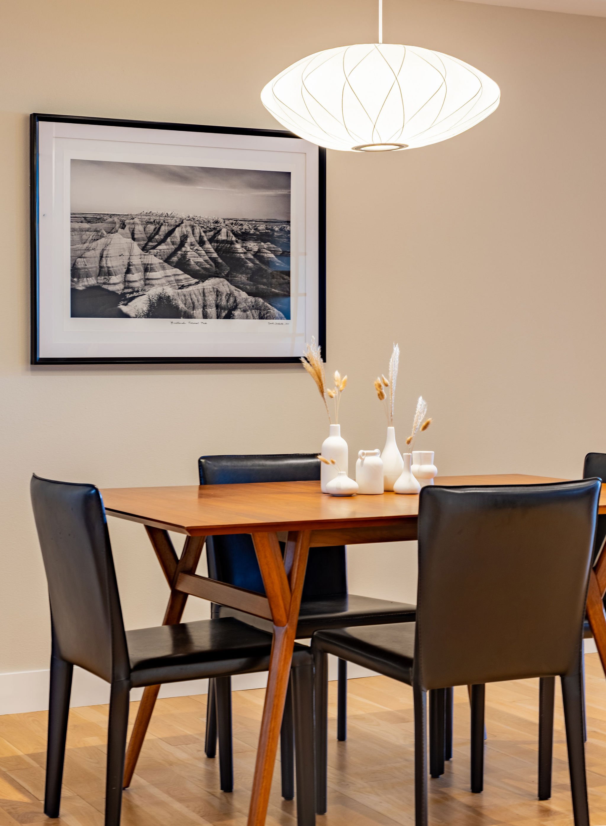 This artwork was selected to appeal to the homeowner's love of outdoors. The black and white photography complements the clean lines of the dining furniture.