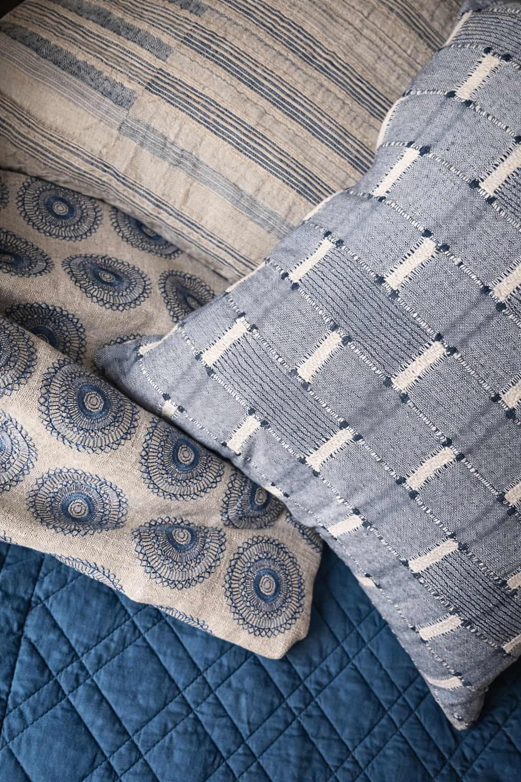 The blue color palette continues in the bedroom, with a mix of texture and pattern.