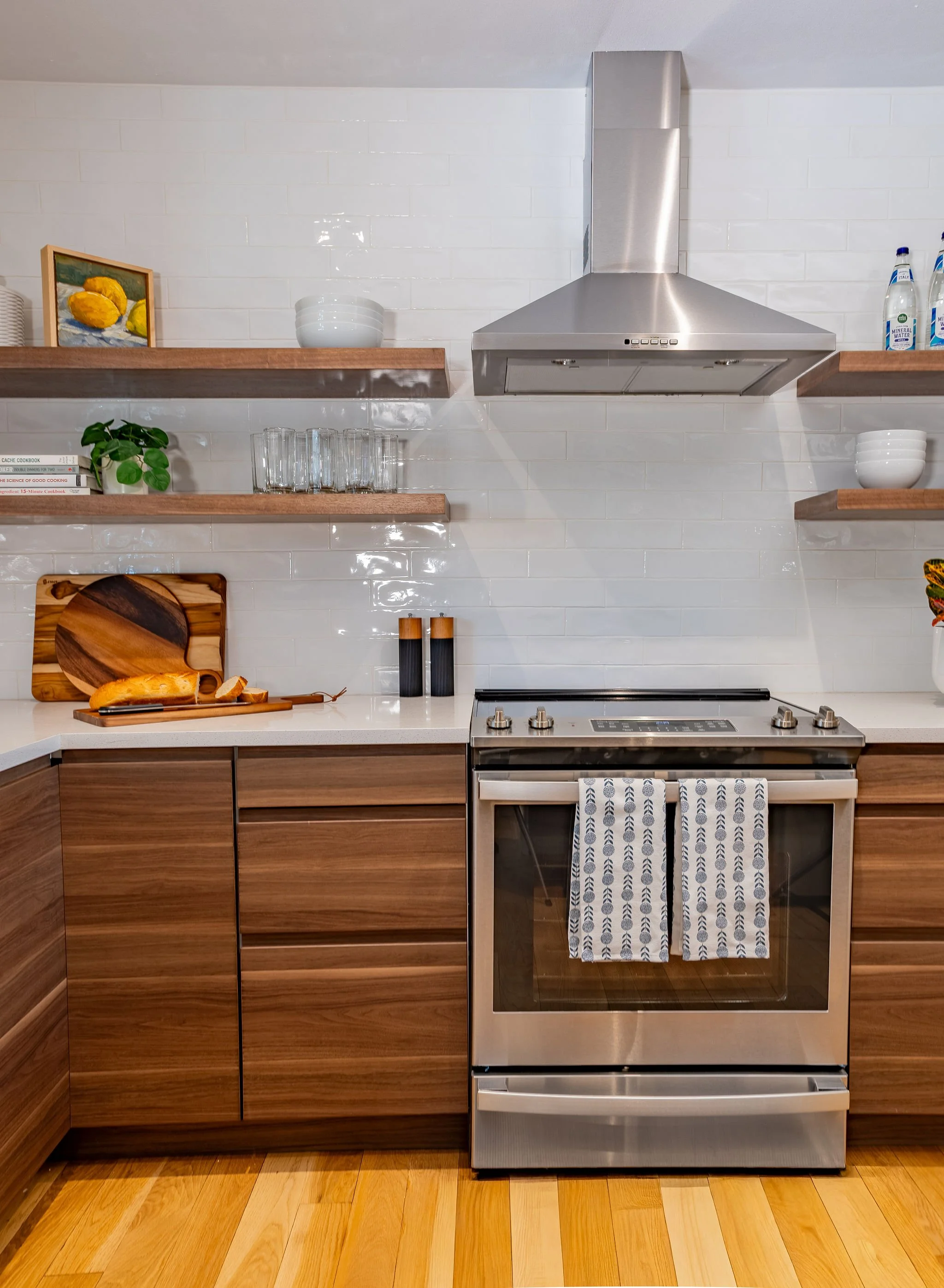 Light, bright subway tile adds to this kitchen feature wall, while floating shelves provide additional storage.