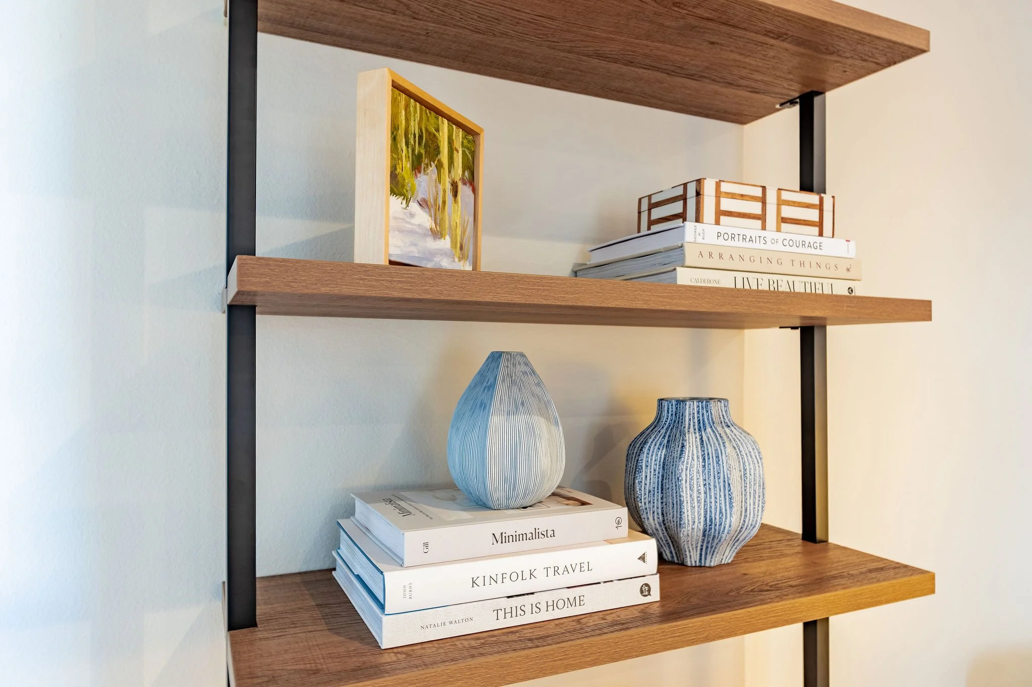 The blue and warm wood-tones color palette is carried through in the bookshelf accessories.