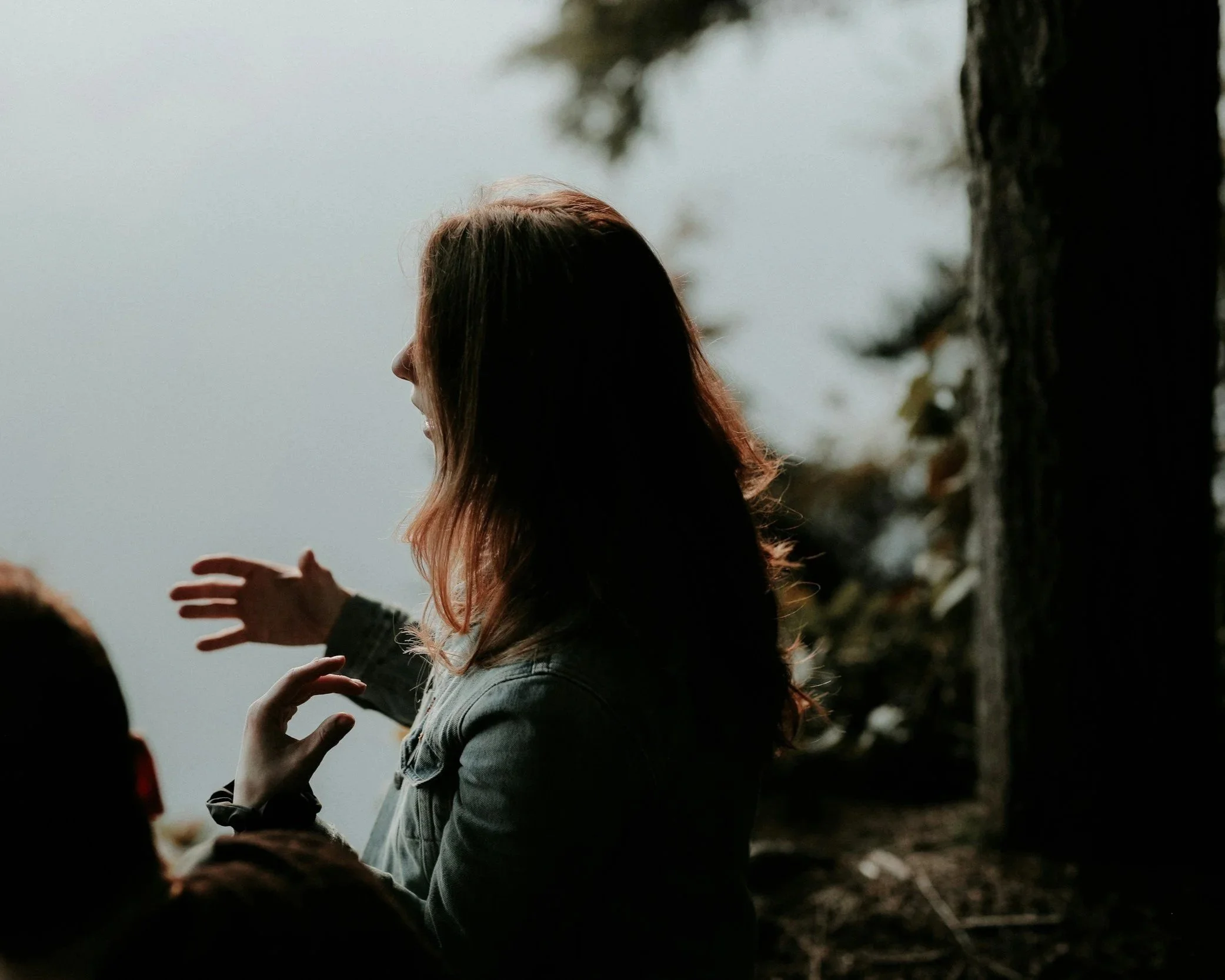 A woman outdoors in a peaceful natural setting, representing emotional well-being, personal growth, and the benefits of cognitive behavioral therapy (CBT).