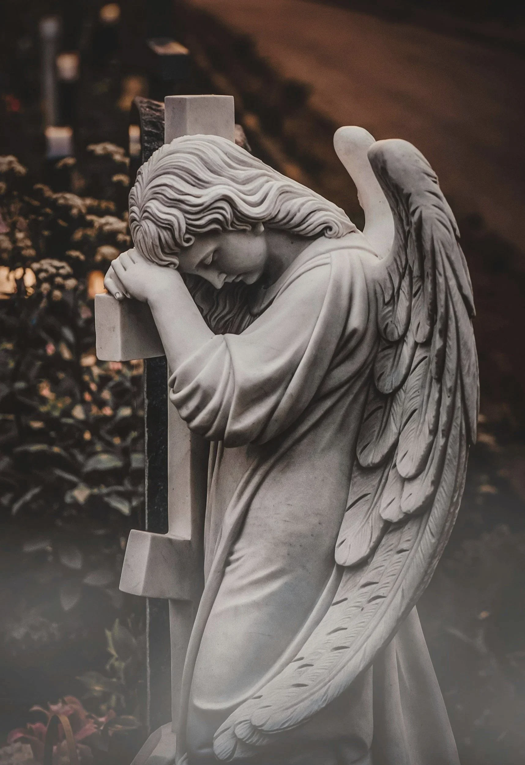 Angel statue draped over a cross, symbolizing grief, faith, and hope through Christian grief counseling and online therapy in Iowa.