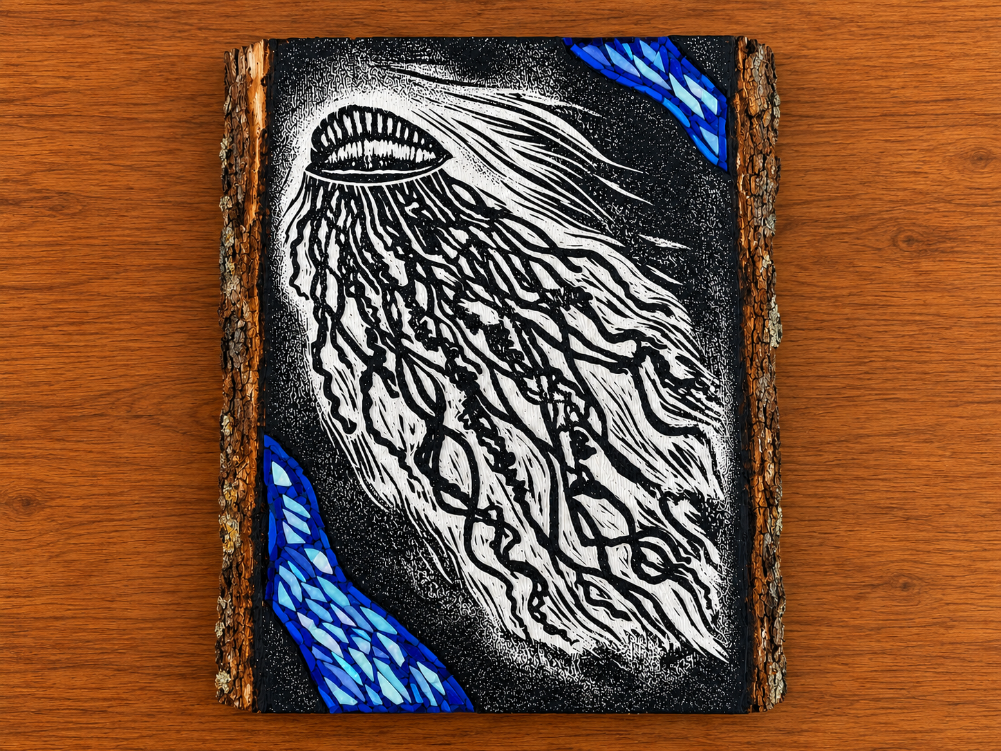 A mixed media painting on a wood slab depicting a Portuguese Man of War with detailed tentacles in black and white, and blue mosaic accents in the corners.