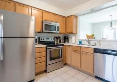 Well-lit kitchen with stainless steel appliances and light wood cabinets