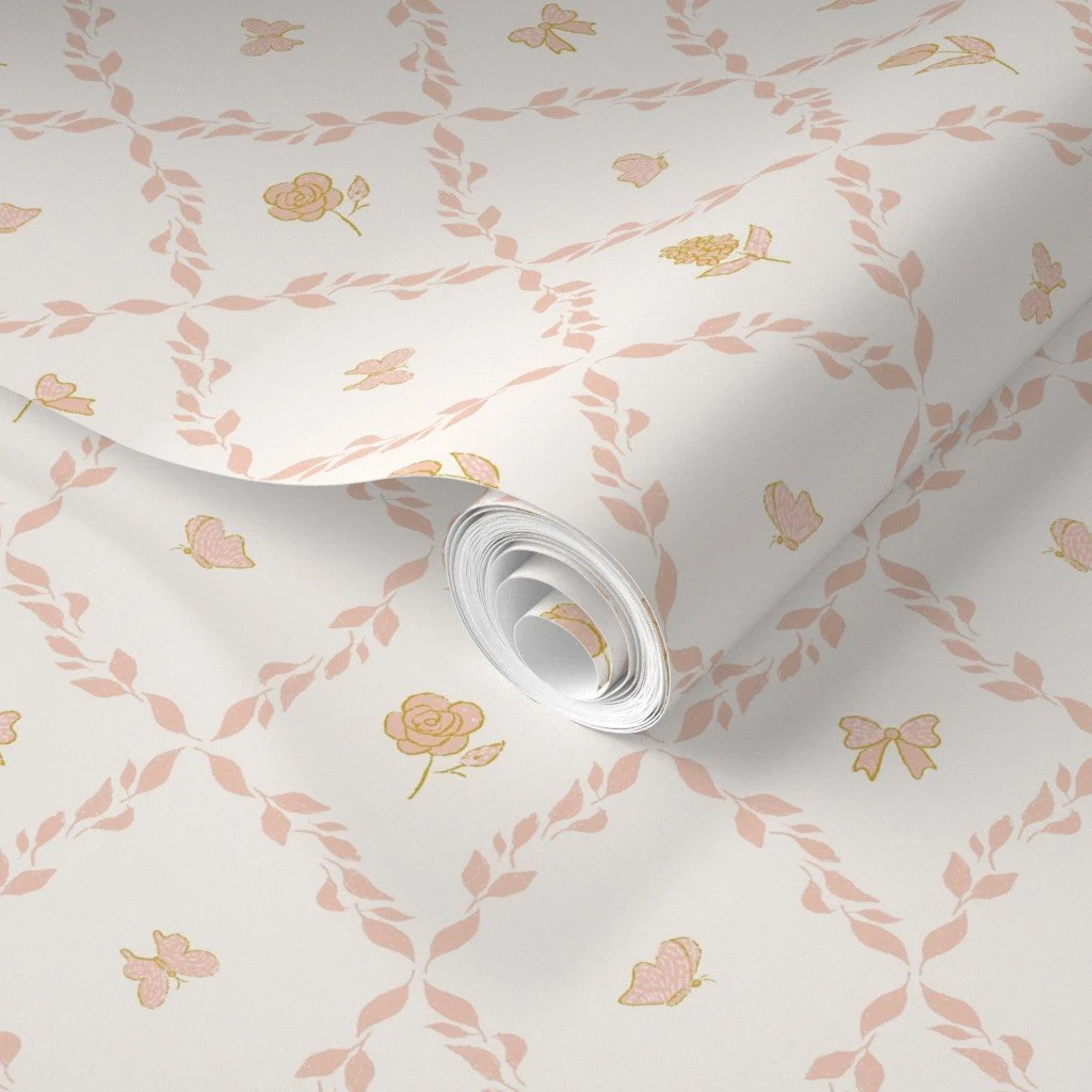 A roll of wallpaper with a feminine seamless pattern of pink roses, pink bows, and pink butterflies. Pattern is available for purchase as wallpaper and fabric at Spoonflower and is also available for art licensing.