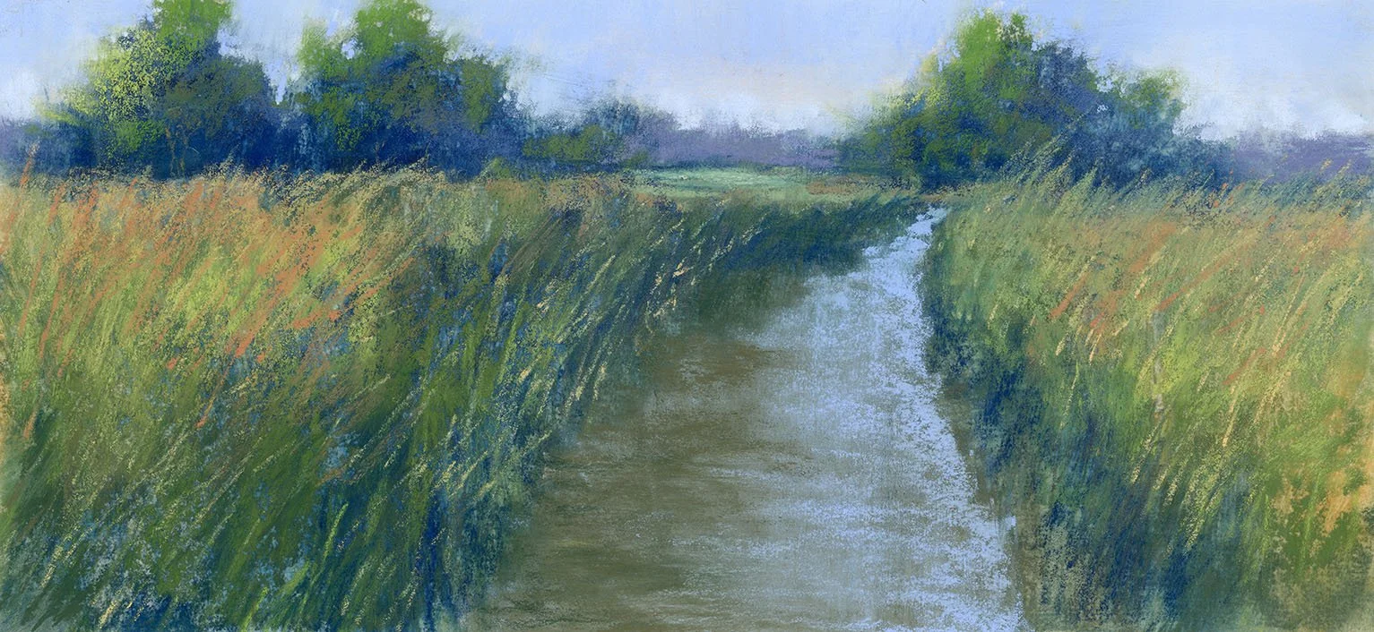 A scenic landscape of a narrow waterway surrounded by tall green grass and trees, with a partly cloudy sky overhead.