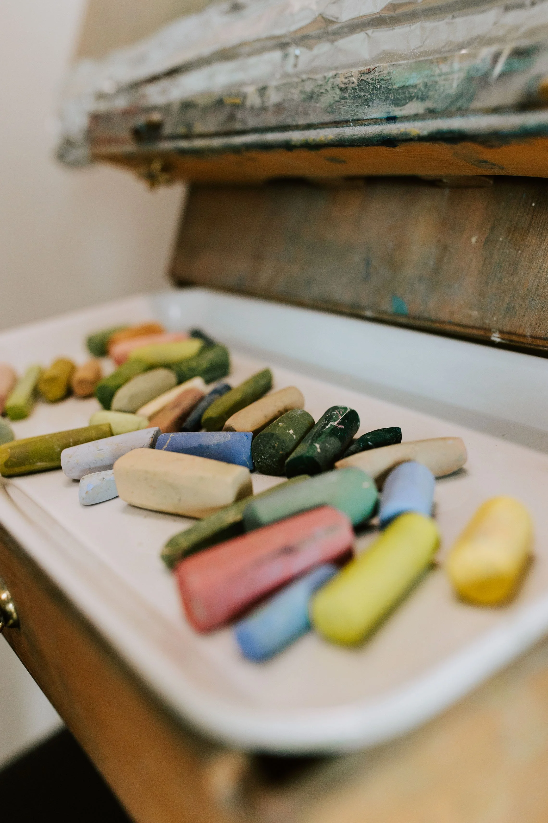 Colorful chalk pastels scattered on a white tray