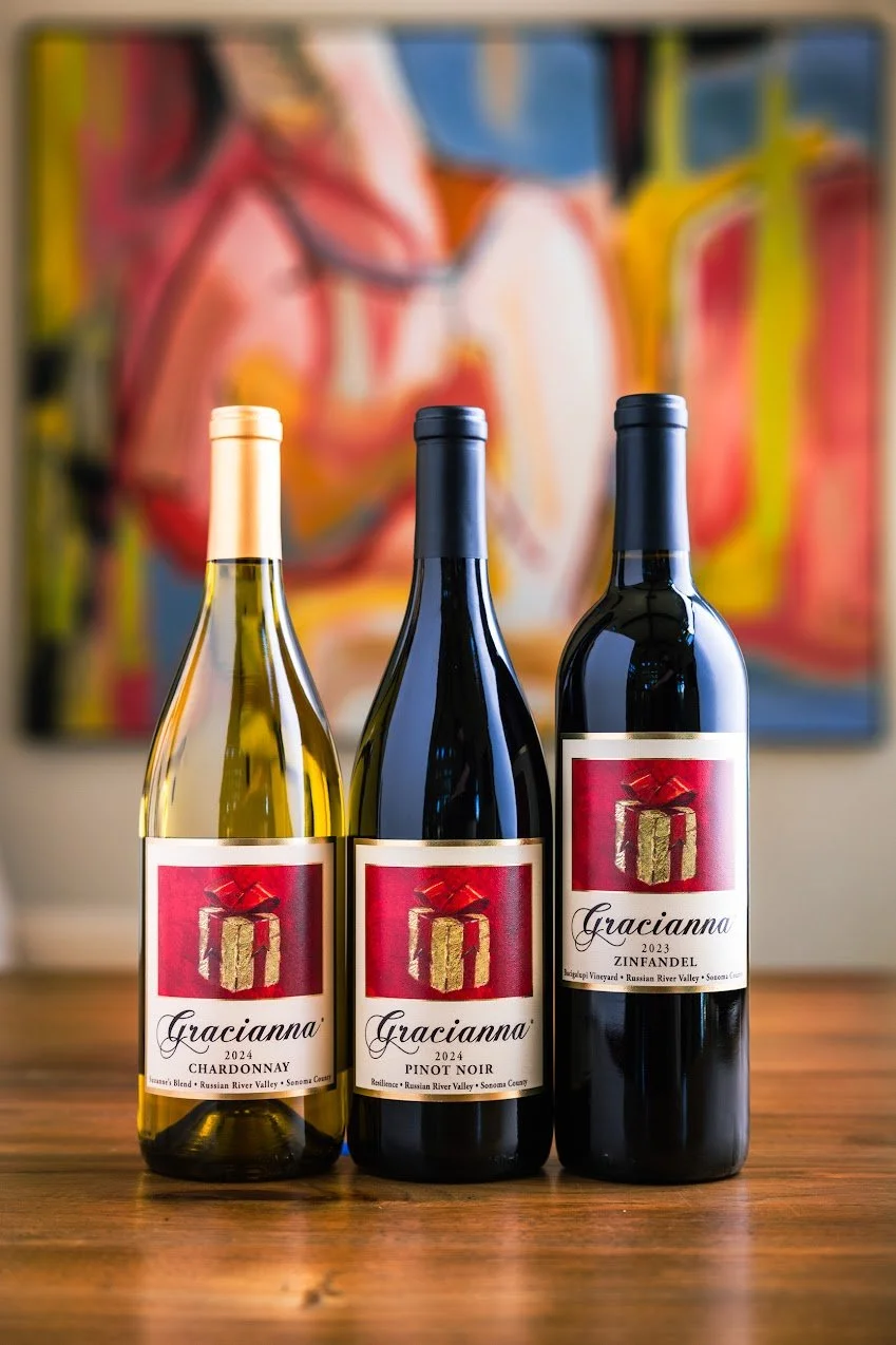 A trio of wines from Gracianna winery infront of a piece of art