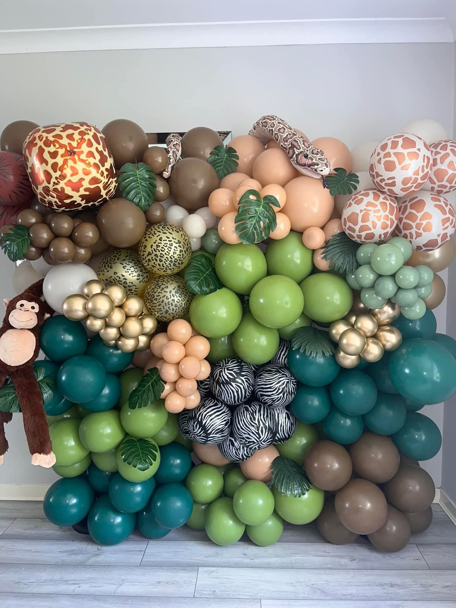 A large balloon display with animal prints, animal figures, and fake leaves, resembling a jungle or safari theme.