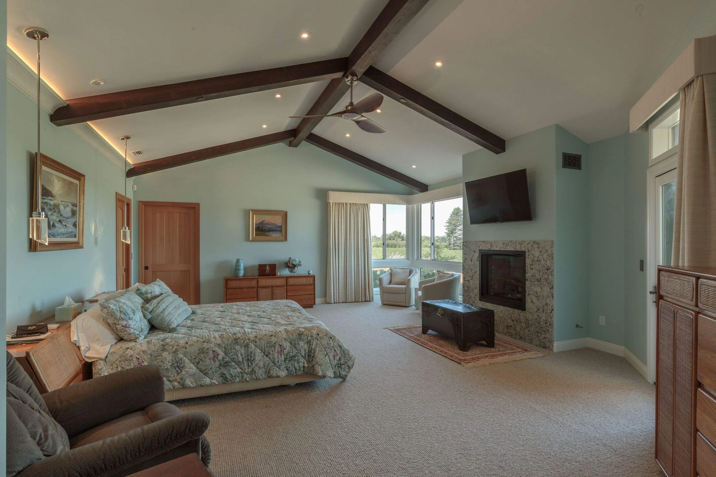 Primary bedroom with exposed wood beams inside luxurious new construction Napa home painted by excellent Bay Area painting company Chroma Colors.