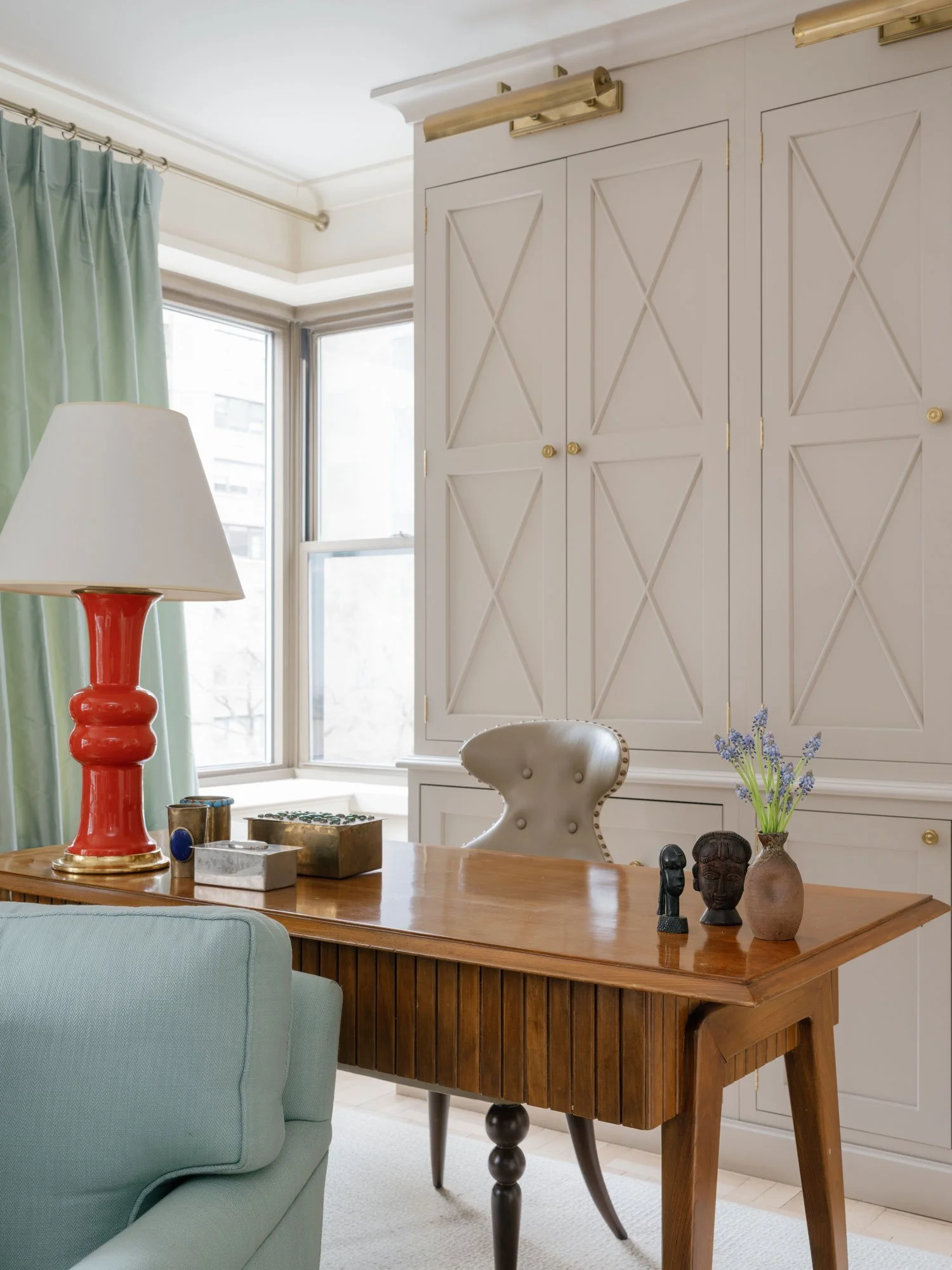 New York City interior design project by Elizabeth Hartz Interior Design featuring tailored millwork, a warm wood writing desk, sculptural table lamp, and a refined, collected workspace.