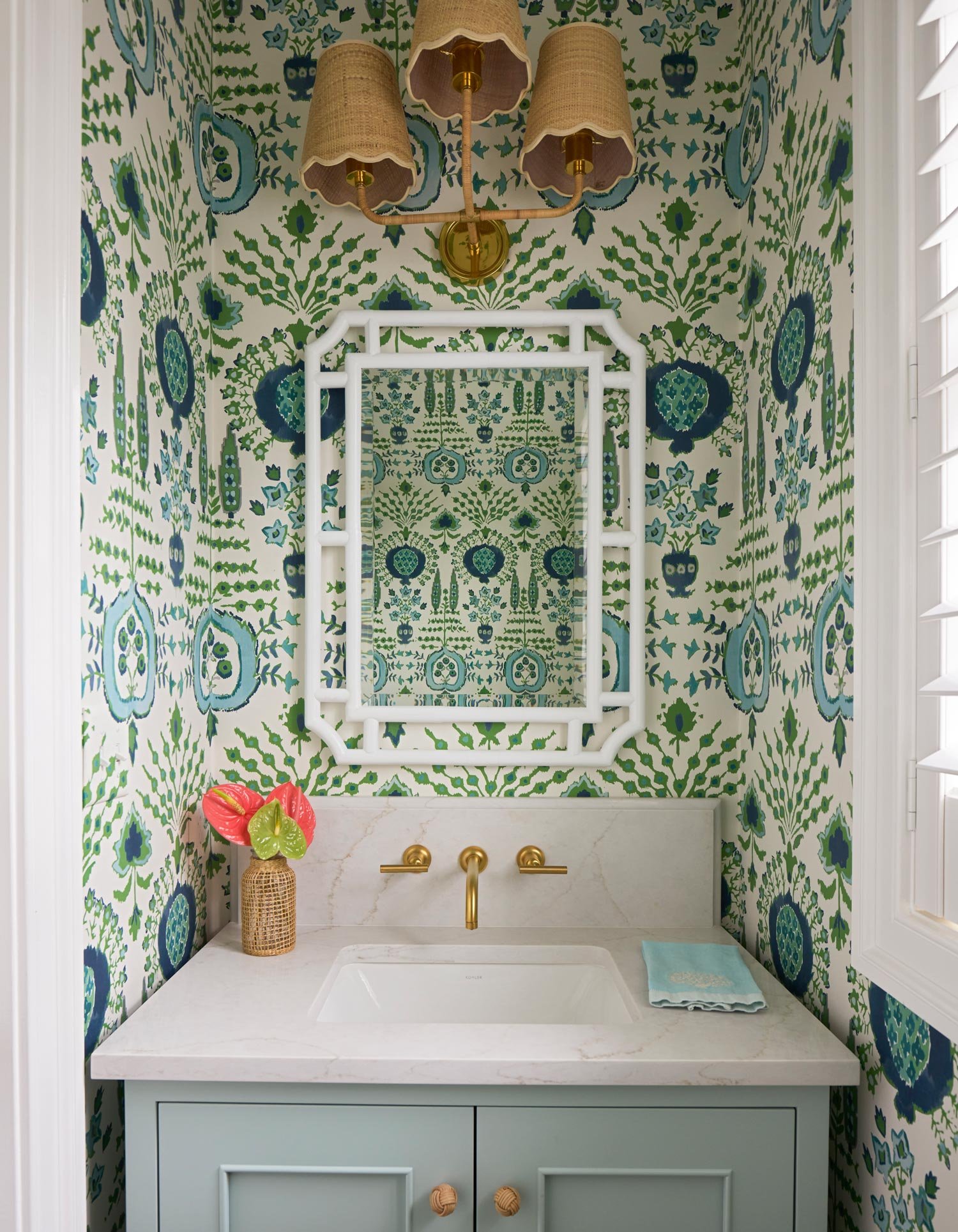 Elizabeth Hartz interior designer Virginia Beach powder bathroom with green and blue patterned wallpaper, custom vanity, marble countertop, brass fixtures, and Palm Beach–inspired coastal detailing
