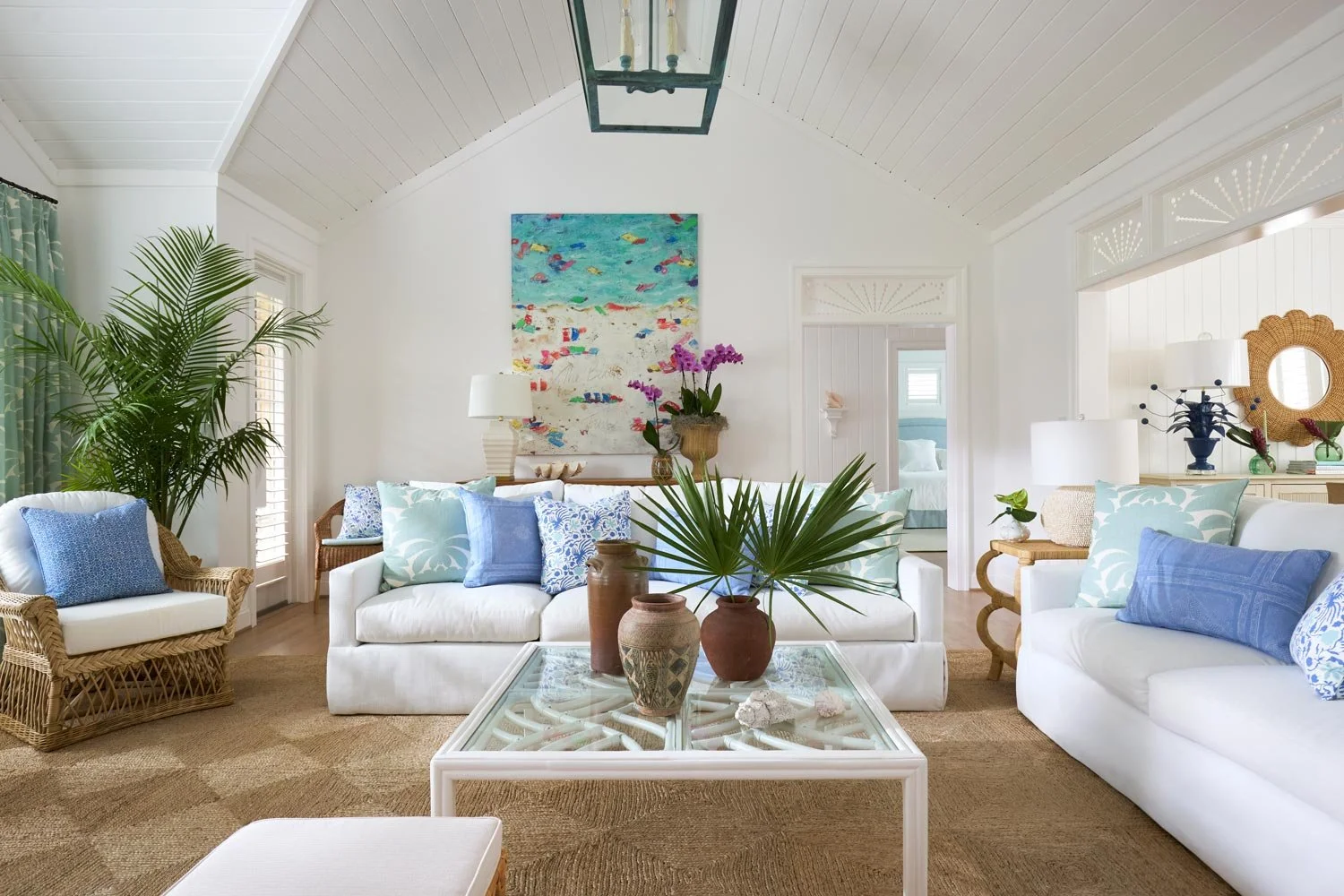 Elizabeth Hartz interior designer Virginia Beach oceanfront living room with white sofas, blue and green coastal accents, woven textures, and a bright Palm Beach–inspired aesthetic