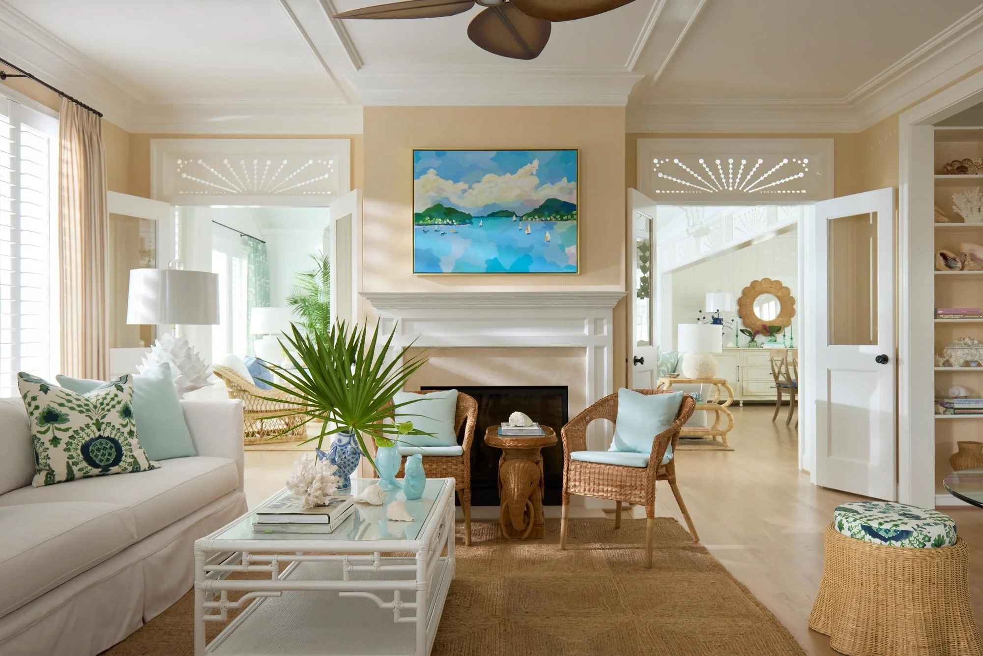 Elizabeth Hartz interior designer Virginia Beach oceanfront living room with fireplace, white seating, woven textures, and soft blue coastal accents opening to light-filled adjoining spaces