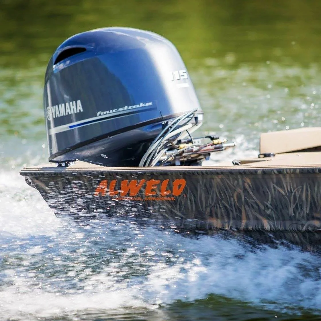 Close-up of a Yamaha 15 horsepower outboard motor mounted on the back of an Alweld aluminum boat moving through the water.