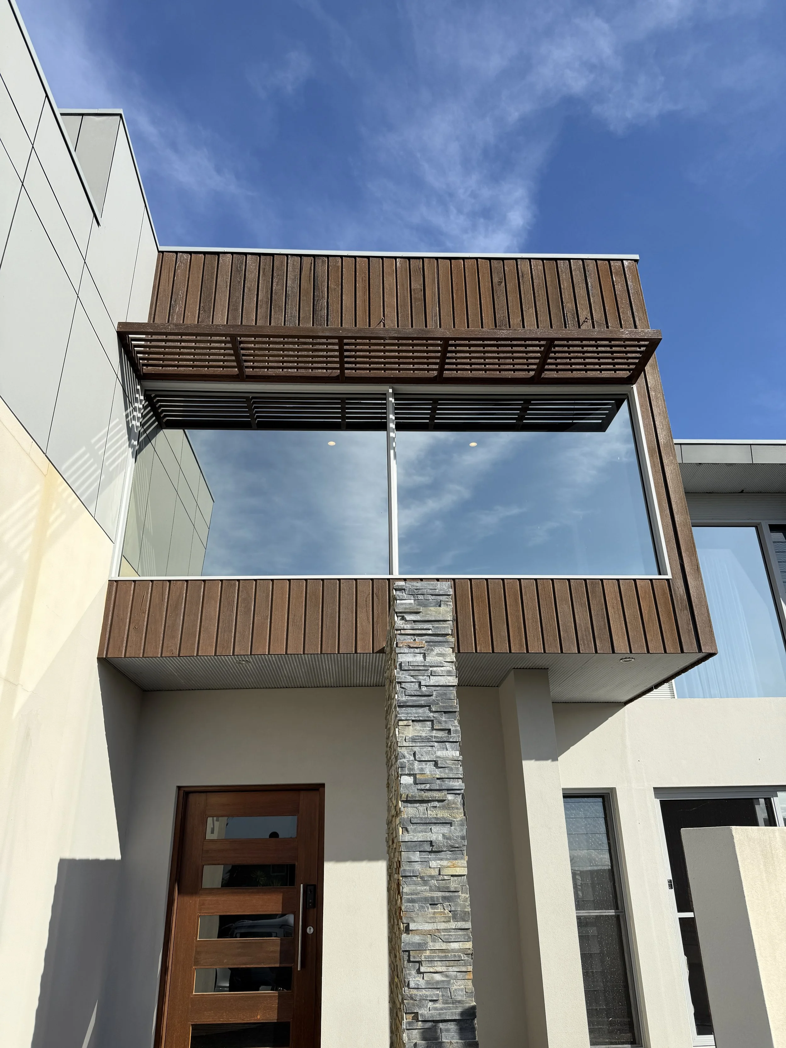 Moder house with large square tinted windows.