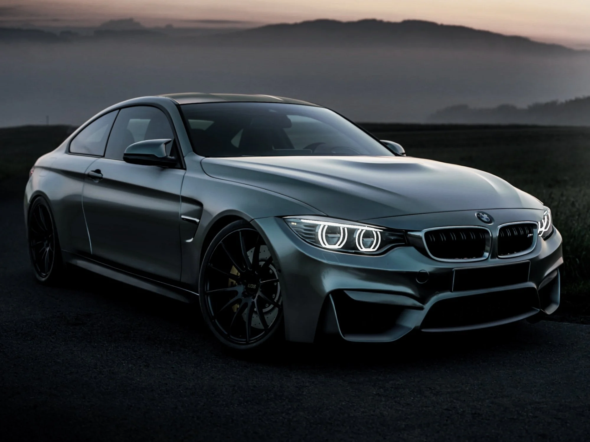 A sleek, dark gray/green vinyl wrapped BMW.