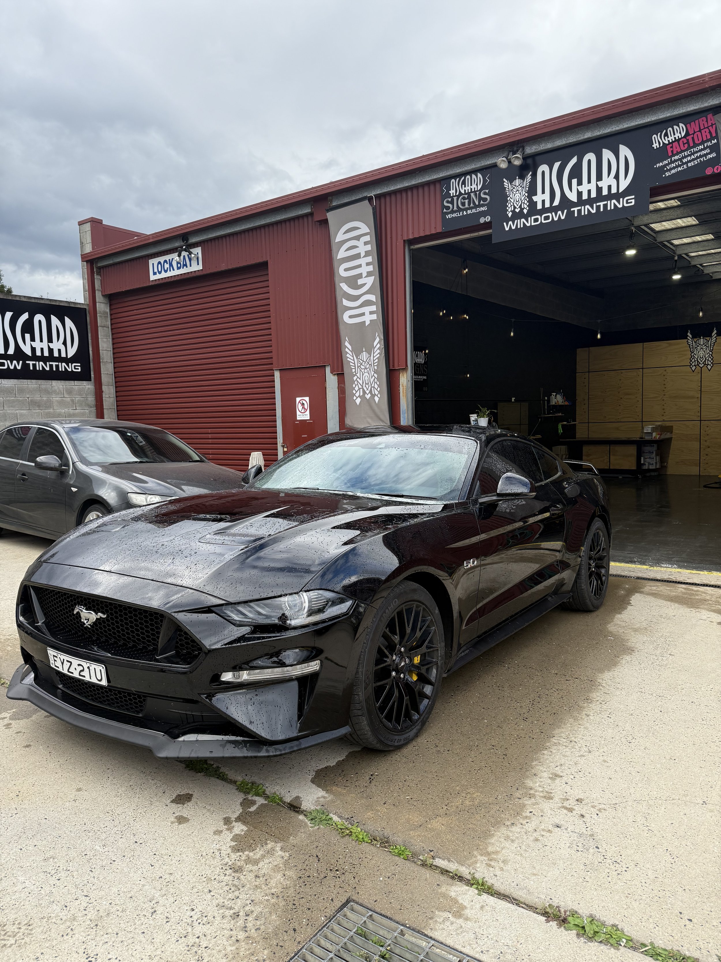 Black Ford Mustang parked outside Asgard Window Tinting workshop in Pambula