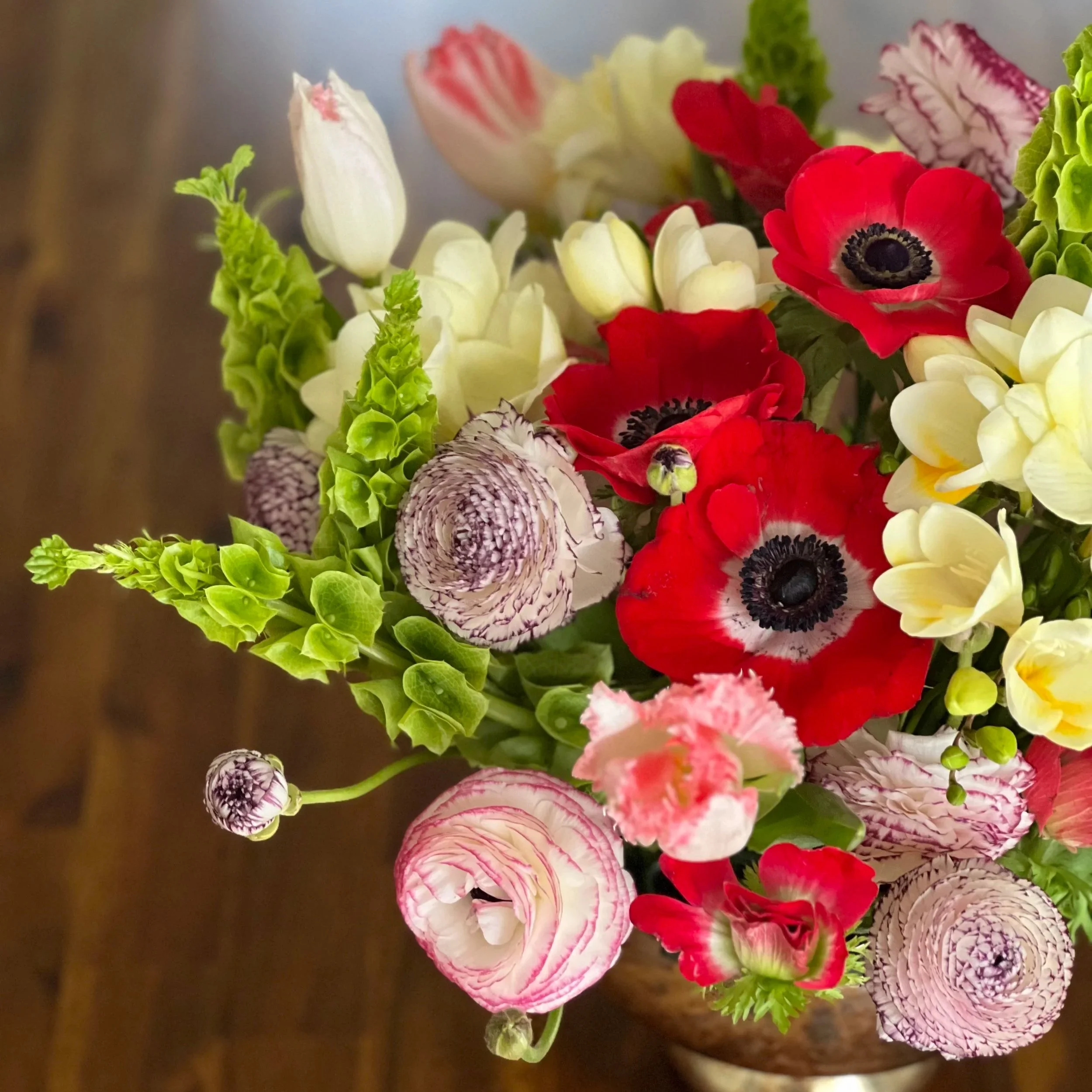 Colorful Easter centerpiece bursting with seasonal blooms — a joyful spring floral design by Wilder Bloom to brighten your holiday table.