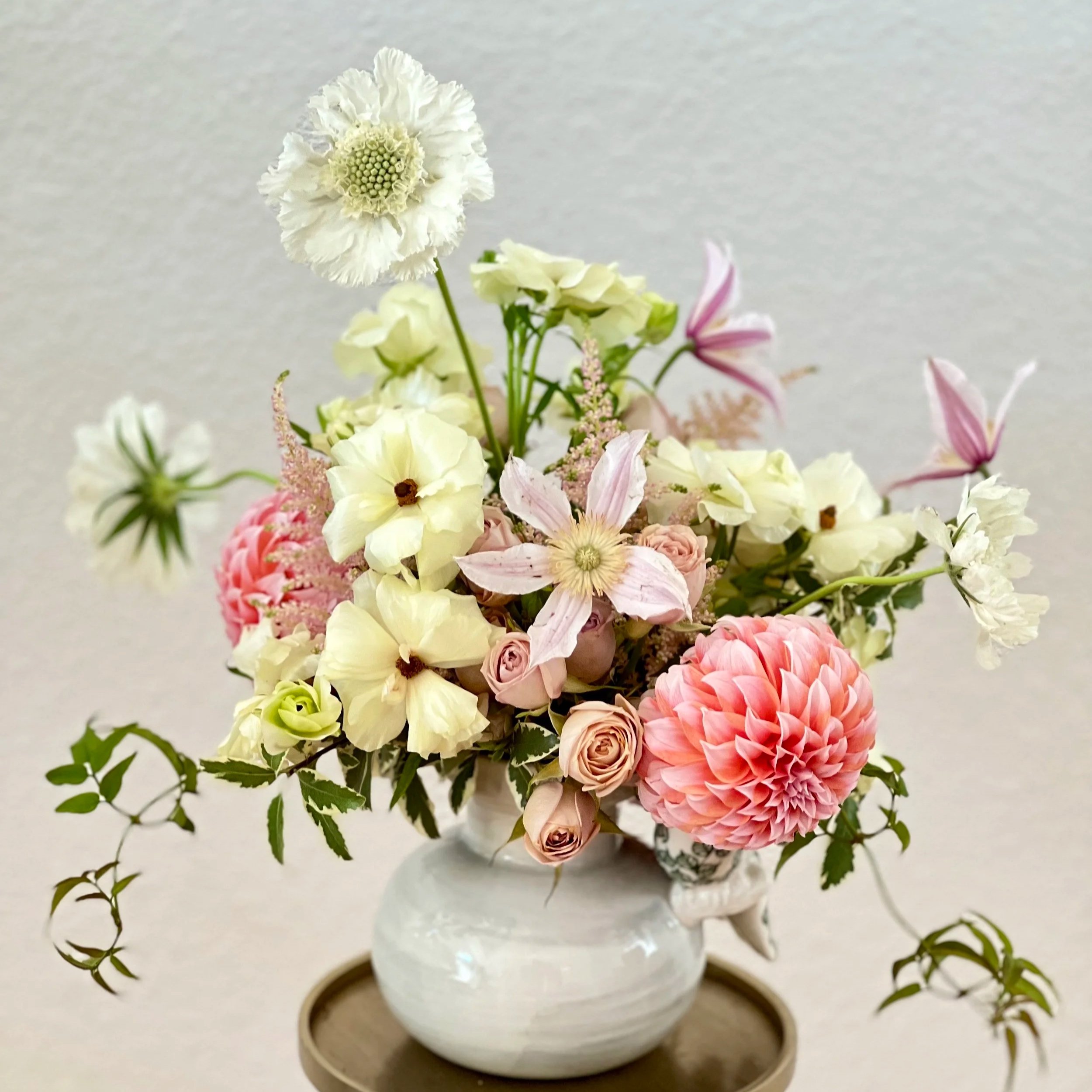 Whimsical floral arrangement featuring dahlias, roses, and clematis.