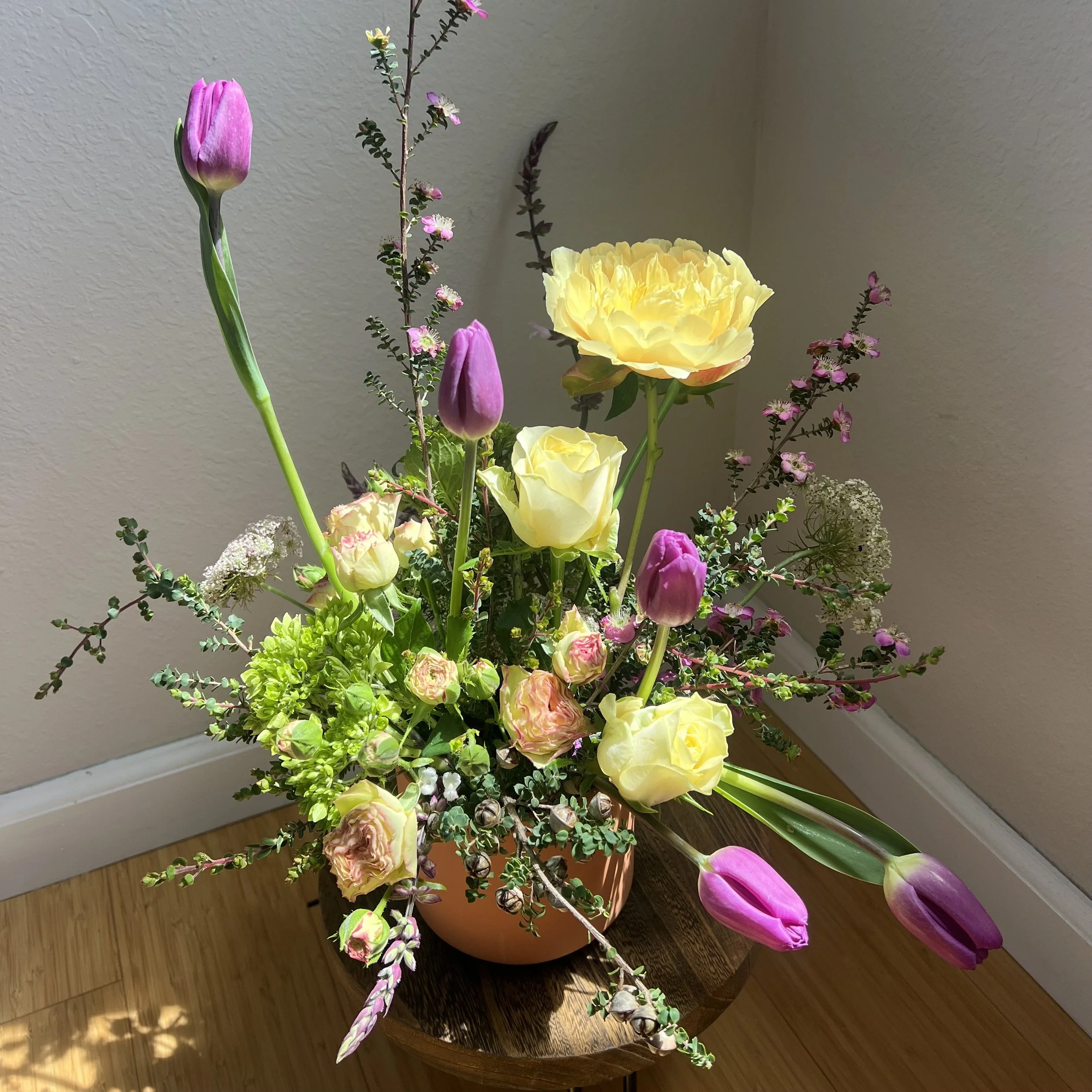 Garden-style Mother’s Day flowers by Wilder Bloom featuring tulips, roses, and peonies in pink and yellow tones.