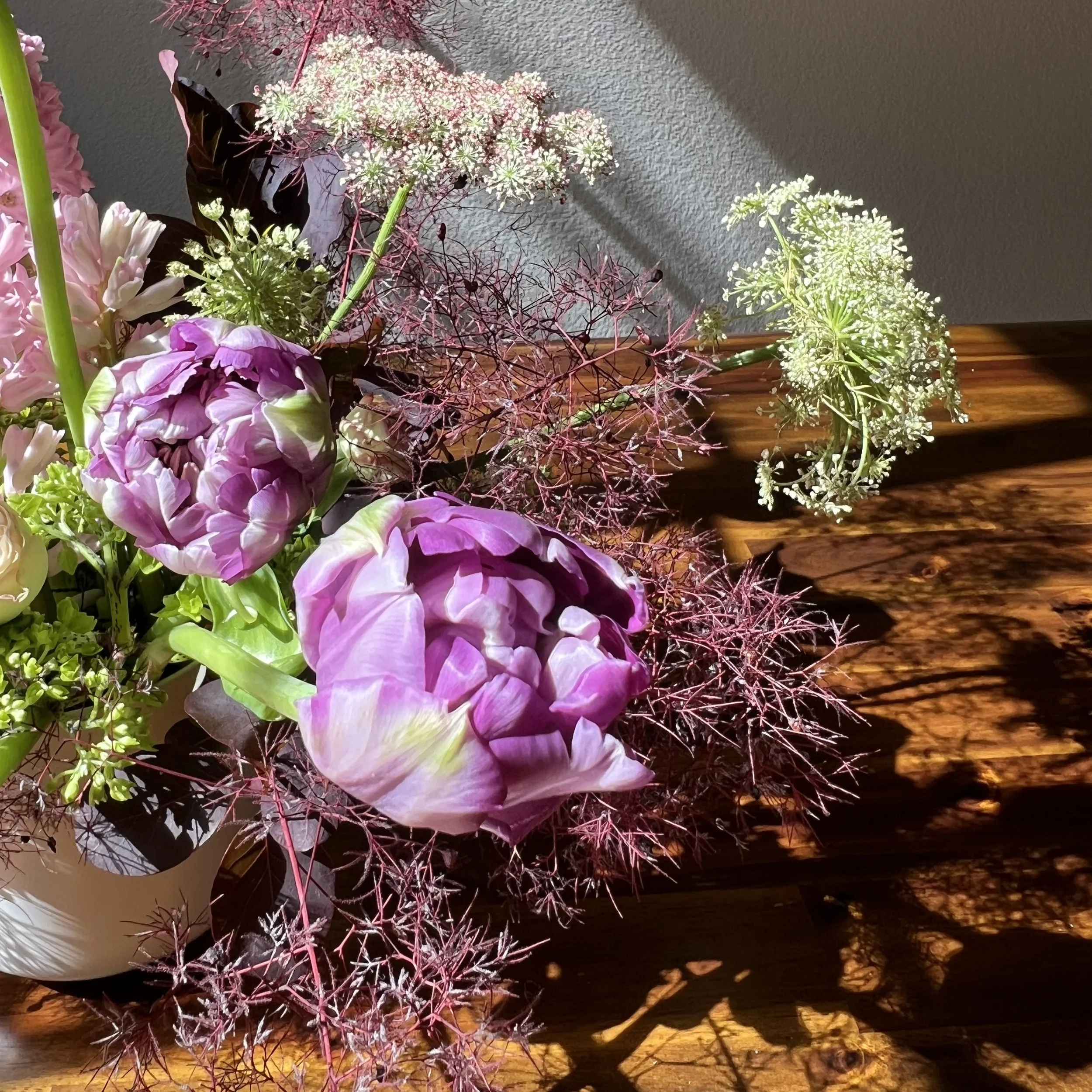 Textural detail of seasonal flowers in a loose, organic bouquet with natural movement.