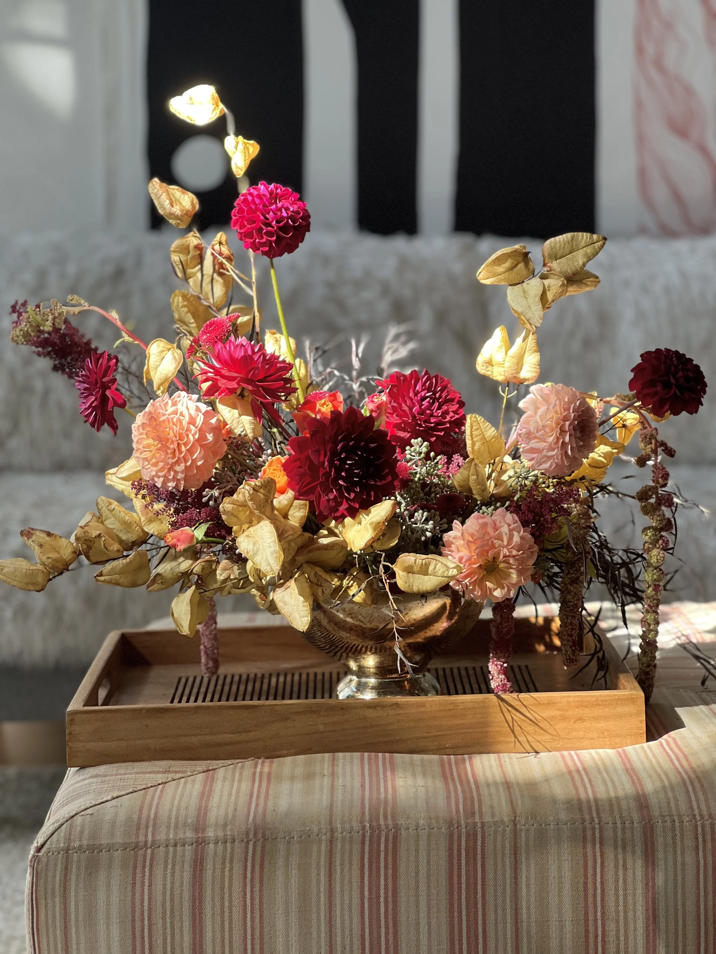 Transition into fall floral arrangement featuring burgundy dahlias, trailing amaranthus and textural brunches. 