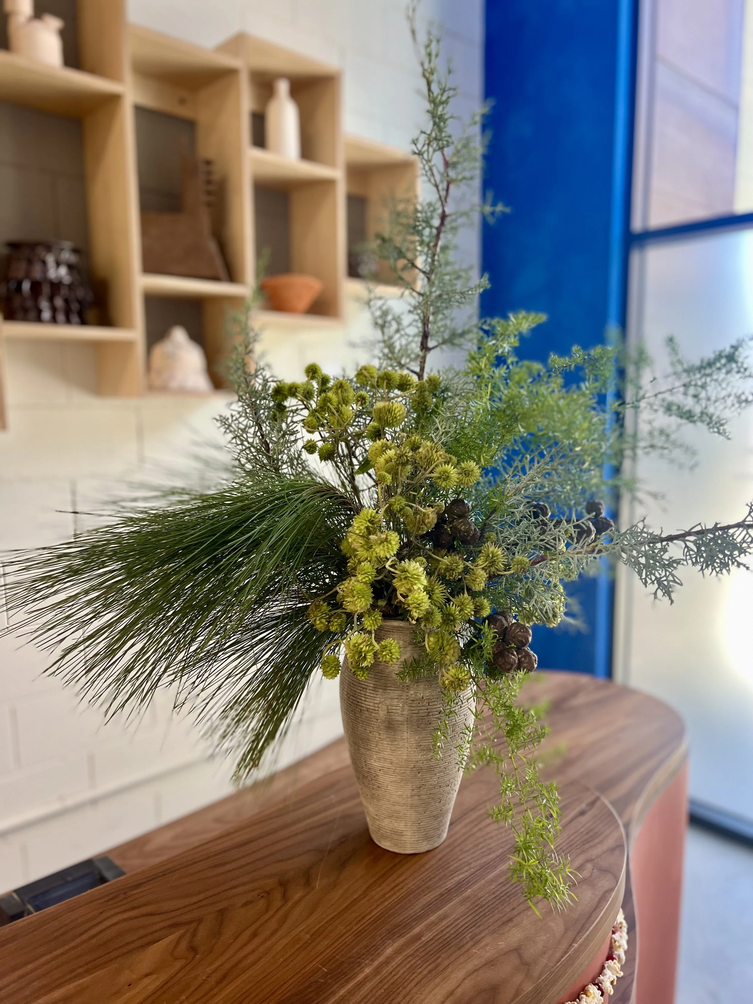 Fresh floral arrangement for a creative space, blending seasonal blooms, movement, and texture.