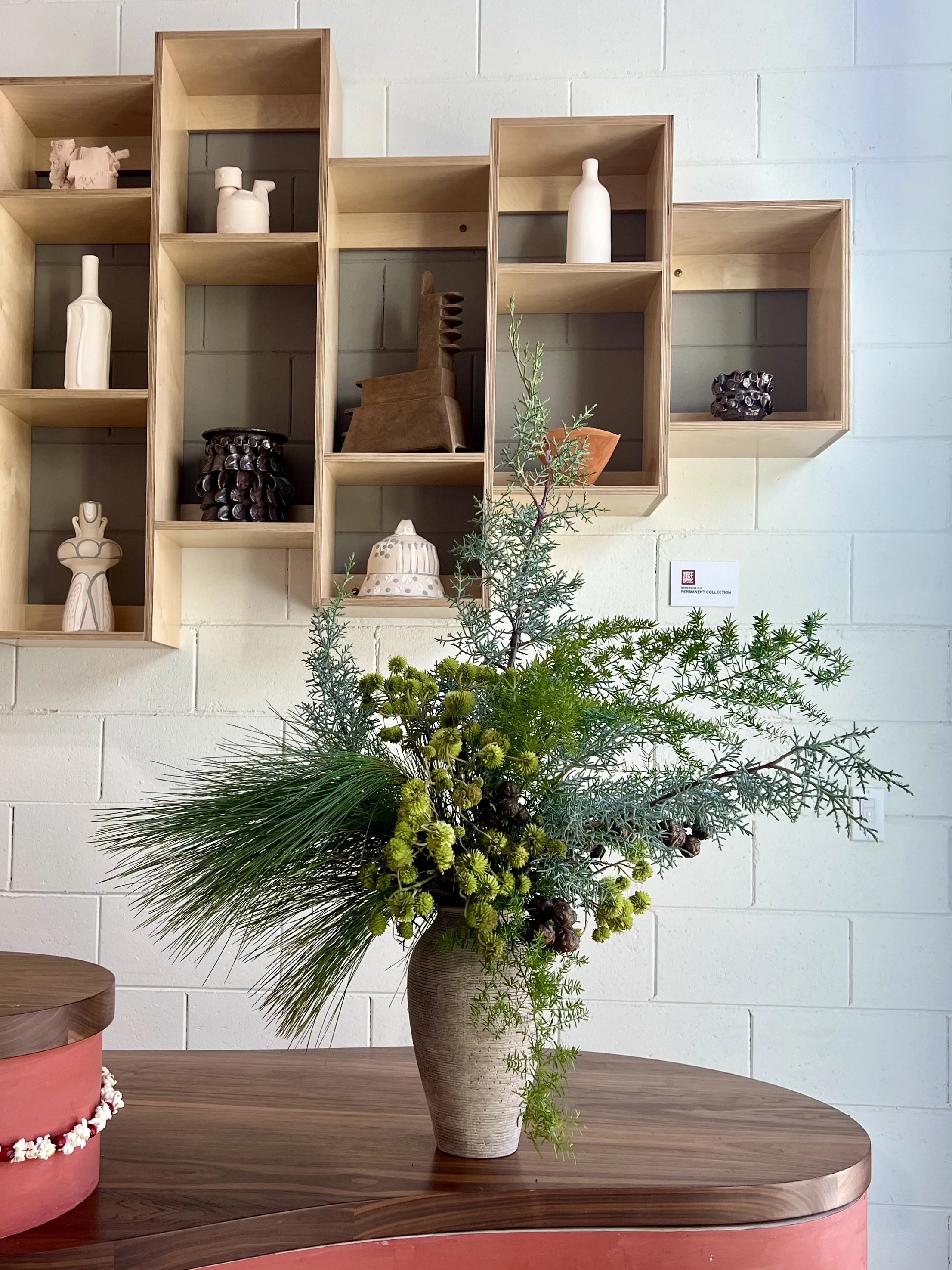 Editorial floral arrangement for a creative studio, featuring seasonal blooms with sculptural lines and soft movement.