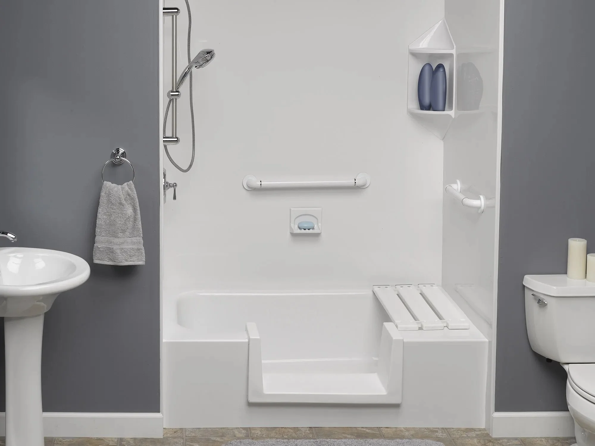 Accessible bathroom with walk-in shower, grab bar, toilet, sink, and storage shelves