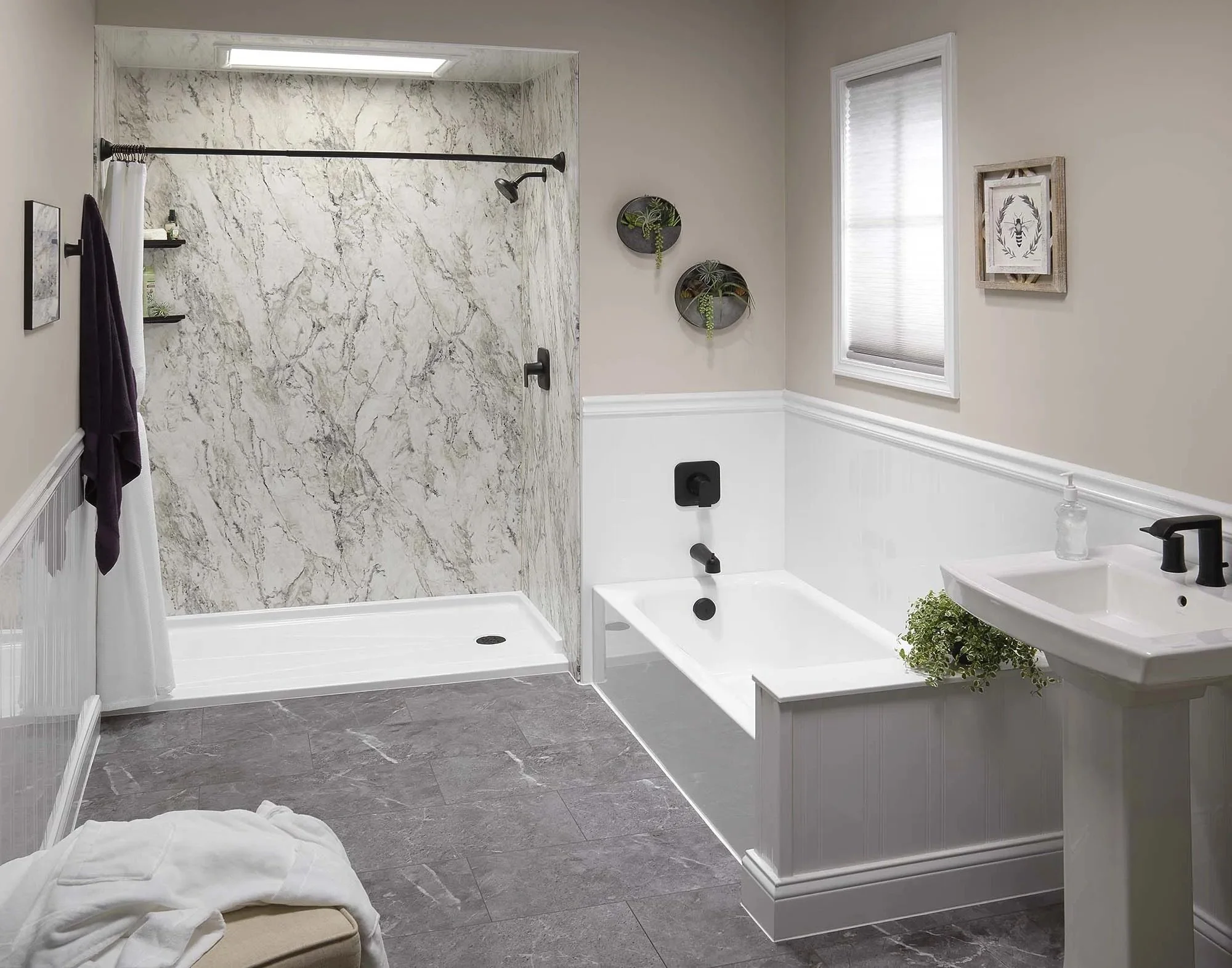 A modern bathroom featuring a walk-in shower with marble walls, a bathtub with black fixtures, a white pedestal sink with a black faucet, a small window with blinds, and decorative wall art and plants.