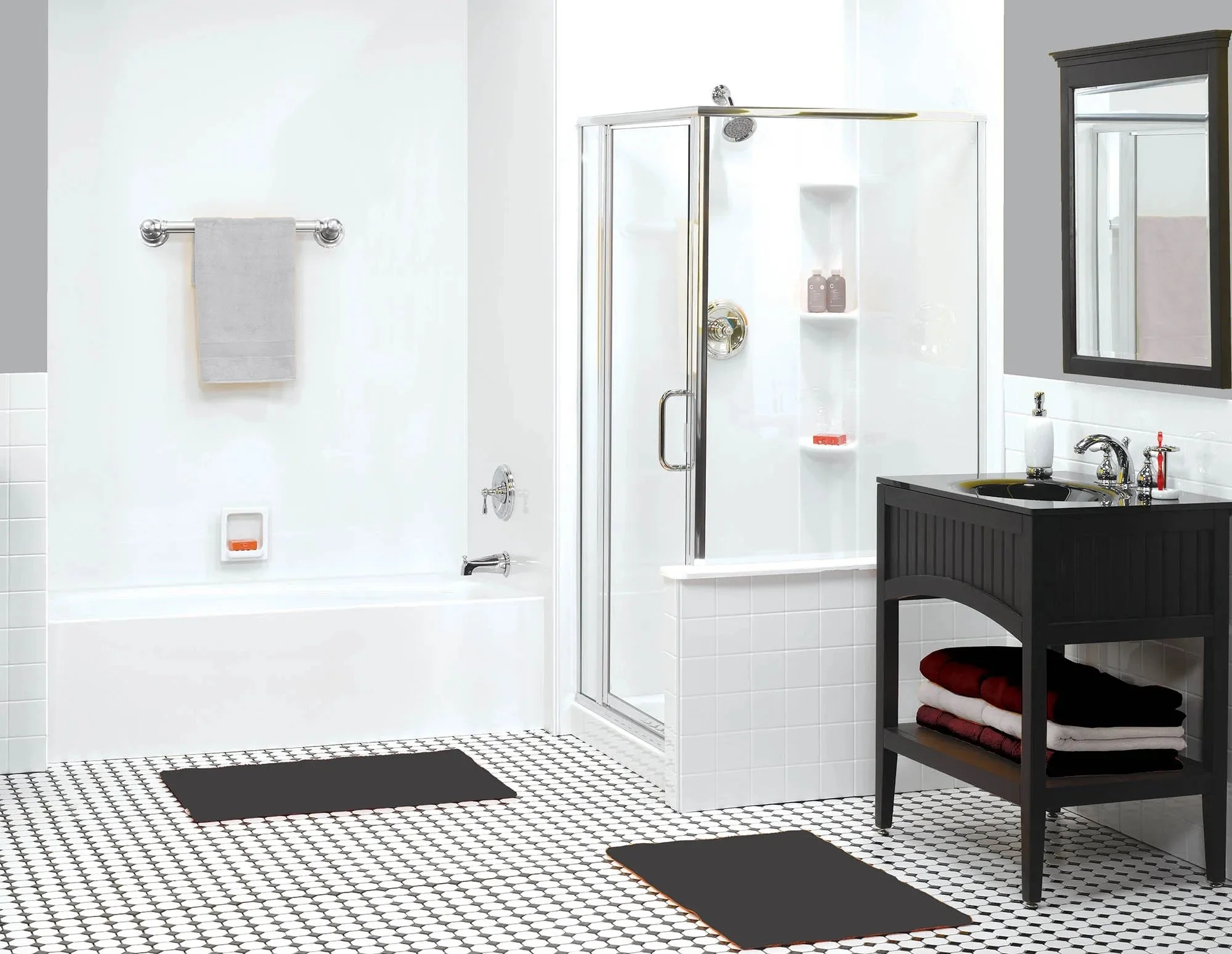 Bathroom with white walls, black and white tiled floor, glass shower enclosure, bathtub, black vanity with folded towels, gray towel on a silver towel bar, and black rugs.