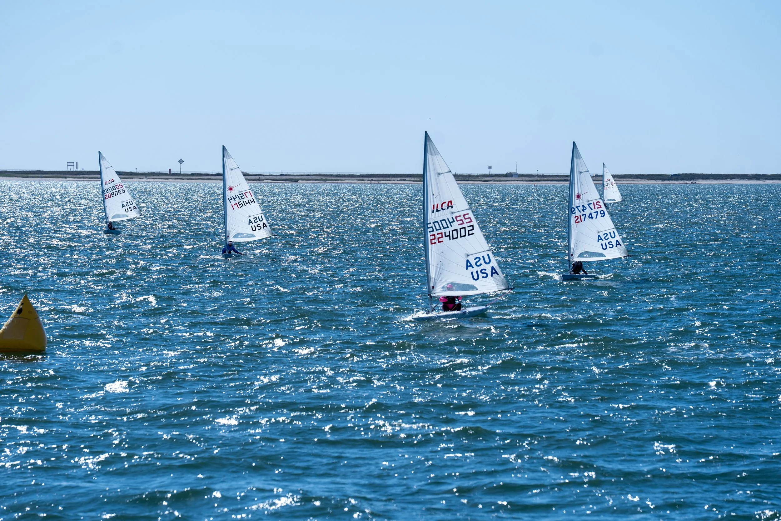 Sailboat racing. Sail number 224002 is leading the fleet at the leeward gate.
