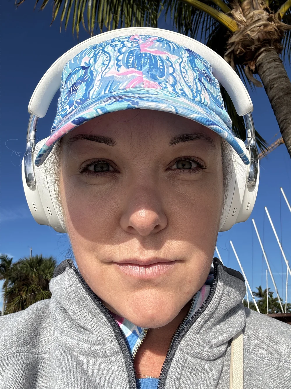 Lauren Wilson rocks out to her playlist wearing Sony headphones and Lilly Pulitzer hat while rigging her ILCA 6 in the Florida sunshine