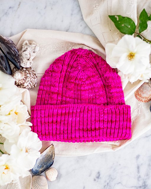A custom designed pink knitted hat used by Lauren Wilson while racing her Olympic Class ILCA 6 sailboat in colder climates. Custom designed pattern from A Bee In The Bonnet - a sponsor of Second Wind Racing - Click here to purchase the pattern