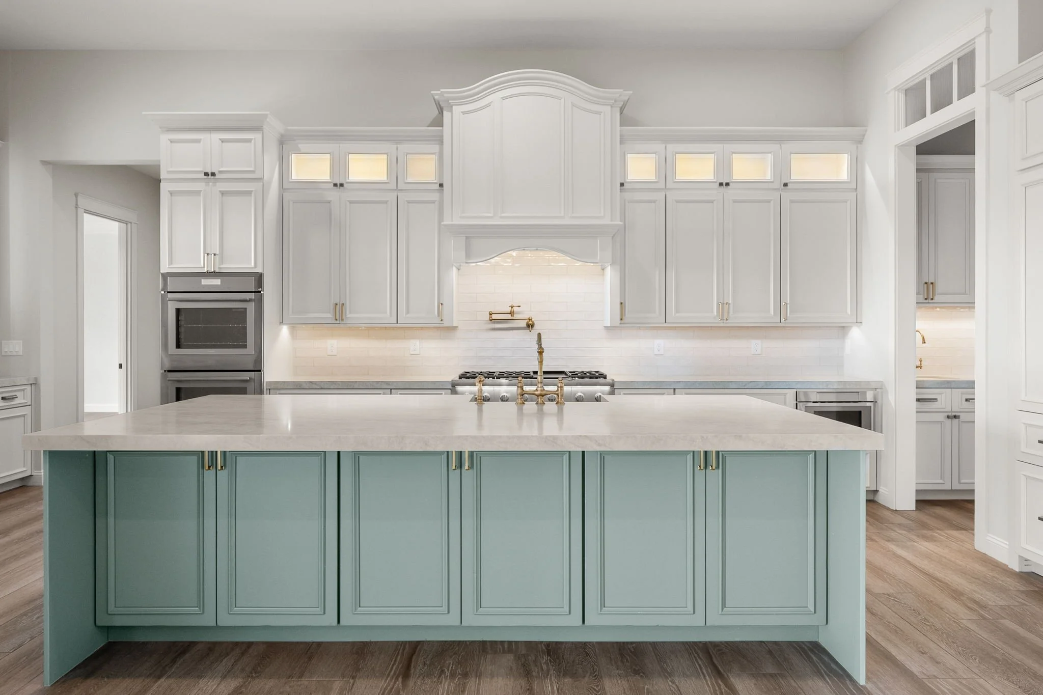 This custom kitchen features premium Shiloh Custom Cabinetry in a timeless Shoji White painted finish, paired with elegant honey bronze hardware from Top Knobs. Designed for both style and durability, this kitchen highlights clean lines, warm tones, 