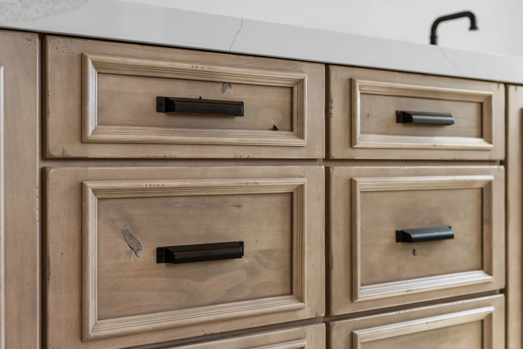 This custom vanity showcases Shiloh Custom Cabinetry crafted from knotty, high-character alder and finished in the popular “White Sands” stain. Accented with bold black hardware from Top Knobs, this design delivers a warm, rustic-modern aesthetic wit