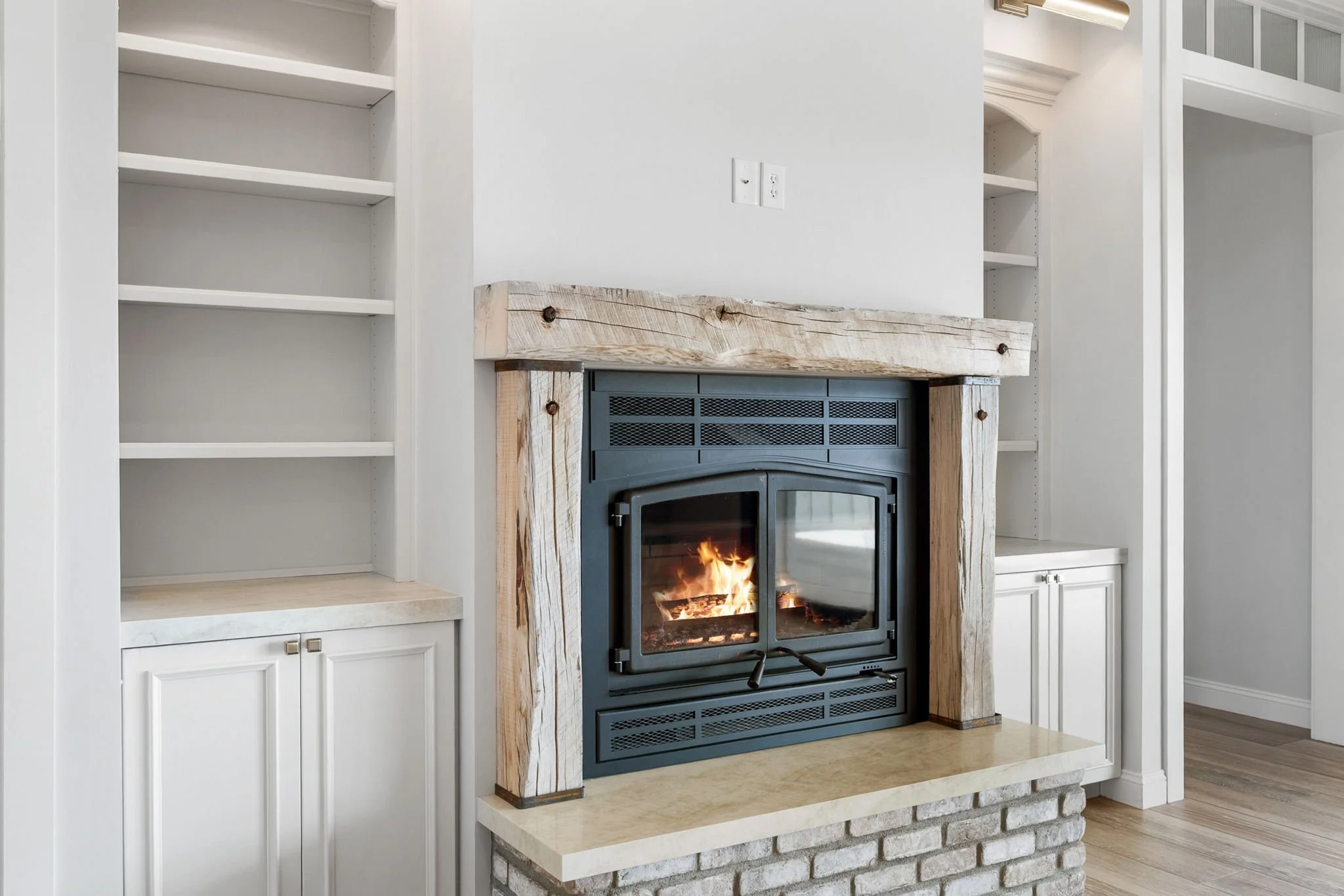 These custom built-in bookcases feature Shiloh Custom Cabinetry in a Shoji White painted finish, accented with premium honey bronze hardware from Top Knobs. Designed to seamlessly integrate into the home, these bookcases provide both functional stora