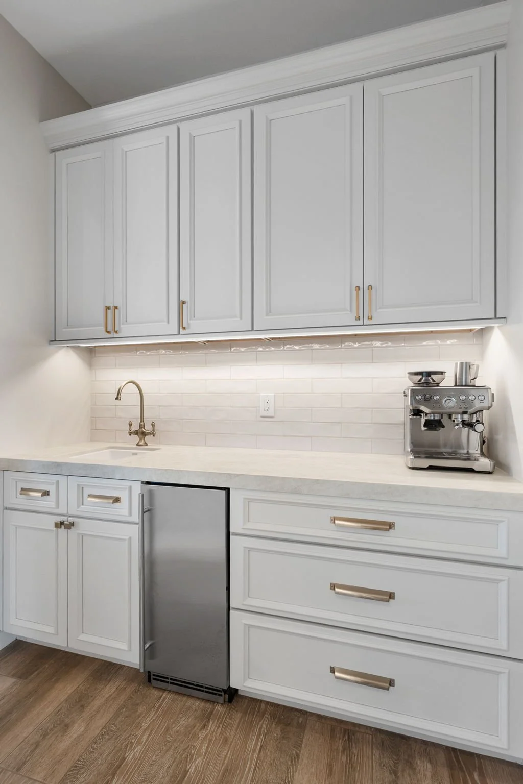 This custom kitchen features premium Shiloh Custom Cabinetry in a timeless Shoji White painted finish, paired with elegant honey bronze hardware from Top Knobs. Designed for both style and durability, this kitchen highlights clean lines, warm tones, 