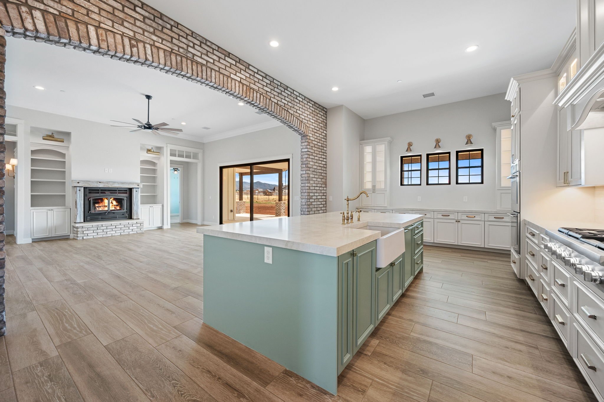 This custom kitchen island showcases Shiloh Custom Cabinetry painted in Evergreen Fog, a modern, nature-inspired color that adds depth and character to any space. Paired with honey bronze hardware from Top Knobs, this island serves as a bold focal po