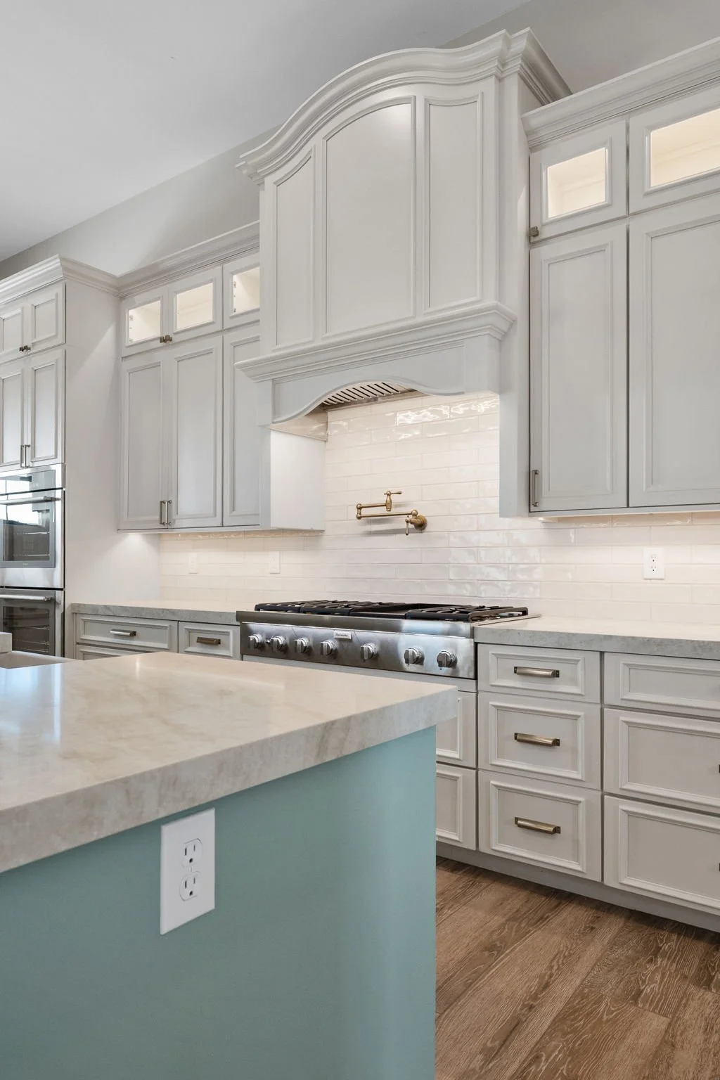 This custom kitchen features premium Shiloh Custom Cabinetry in a timeless Shoji White painted finish, paired with elegant honey bronze hardware from Top Knobs. Designed for both style and durability, this kitchen highlights clean lines, warm tones, 