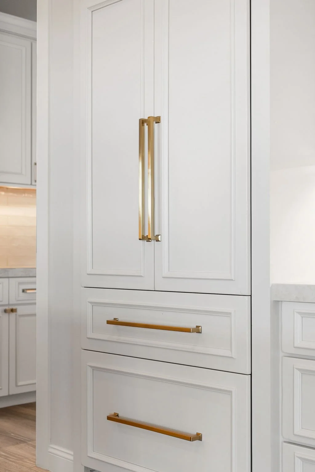This custom kitchen features premium Shiloh Custom Cabinetry in a timeless Shoji White painted finish, paired with elegant honey bronze hardware from Top Knobs. Designed for both style and durability, this kitchen highlights clean lines, warm tones, 