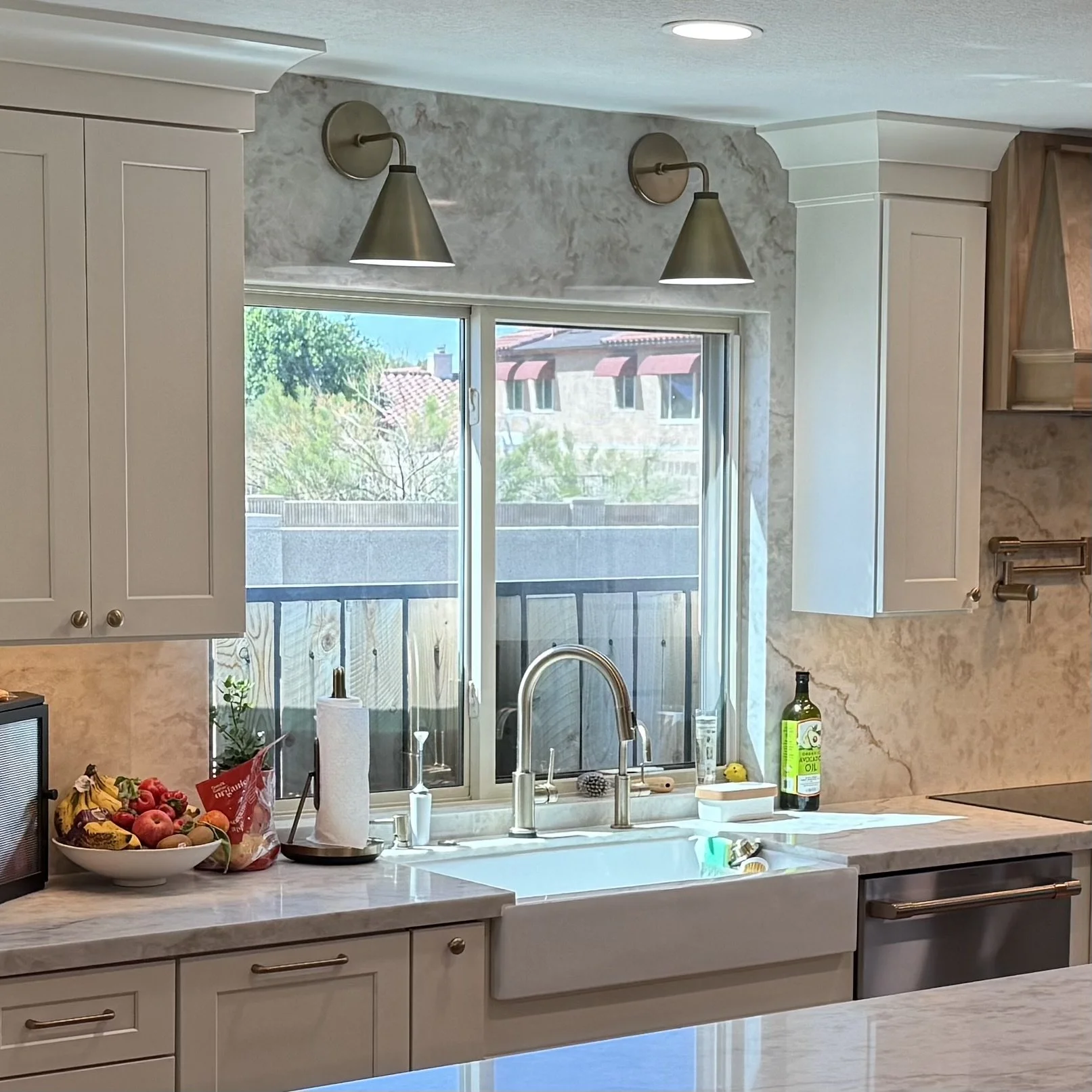 Antique white shaker cabinetry with quartz backsplash