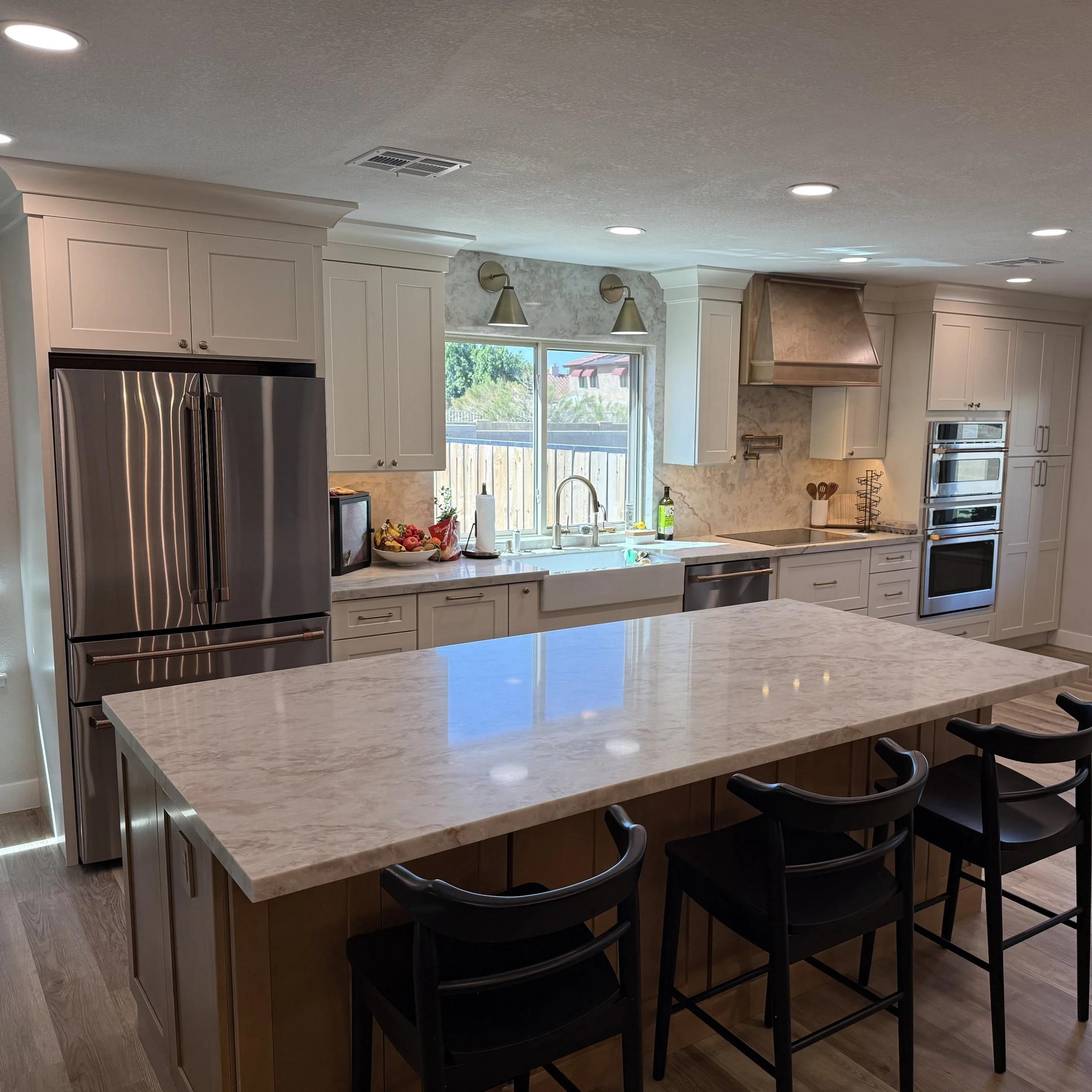 Antique white shaker cabinetry with quartz backsplash