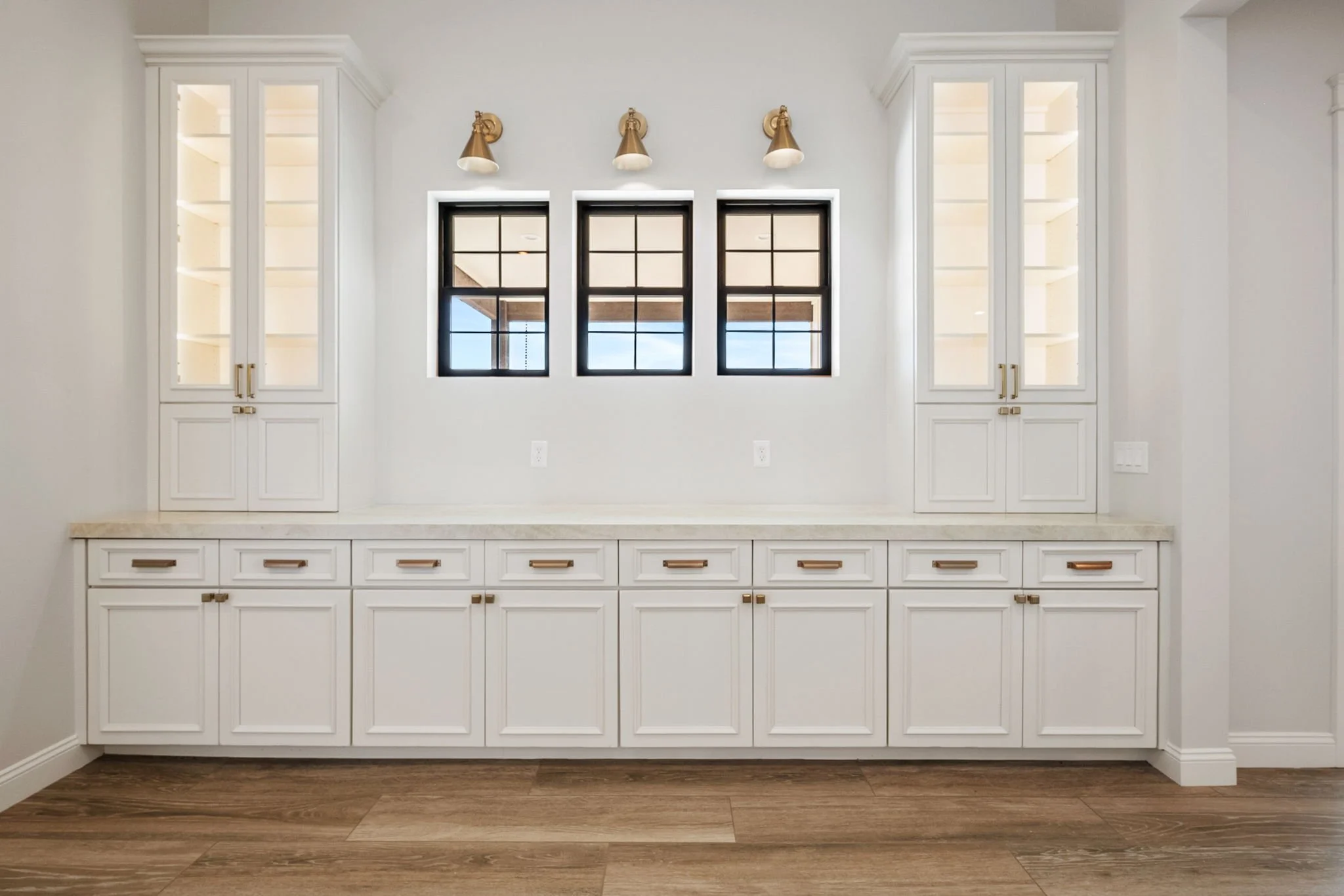 This custom kitchen features premium Shiloh Custom Cabinetry in a timeless Shoji White painted finish, paired with elegant honey bronze hardware from Top Knobs. Designed for both style and durability, this kitchen highlights clean lines, warm tones, 